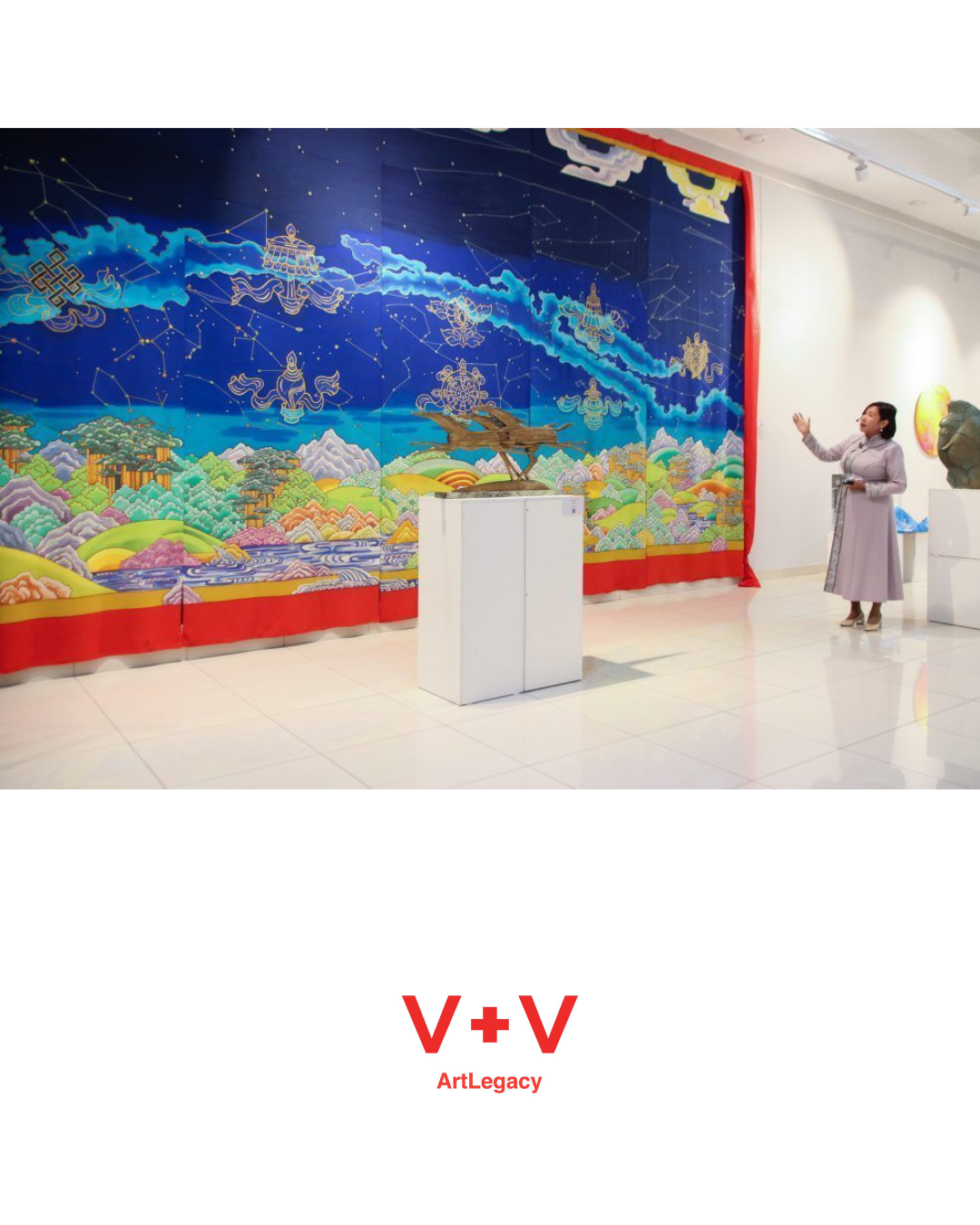 Gallery with vibrant mural depicting celestial elements and landscapes, a woman in a gray dress gesturing towards the art, sculpture on a pedestal in the foreground, and the logo 'V+V ArtLegacy' at the bottom.