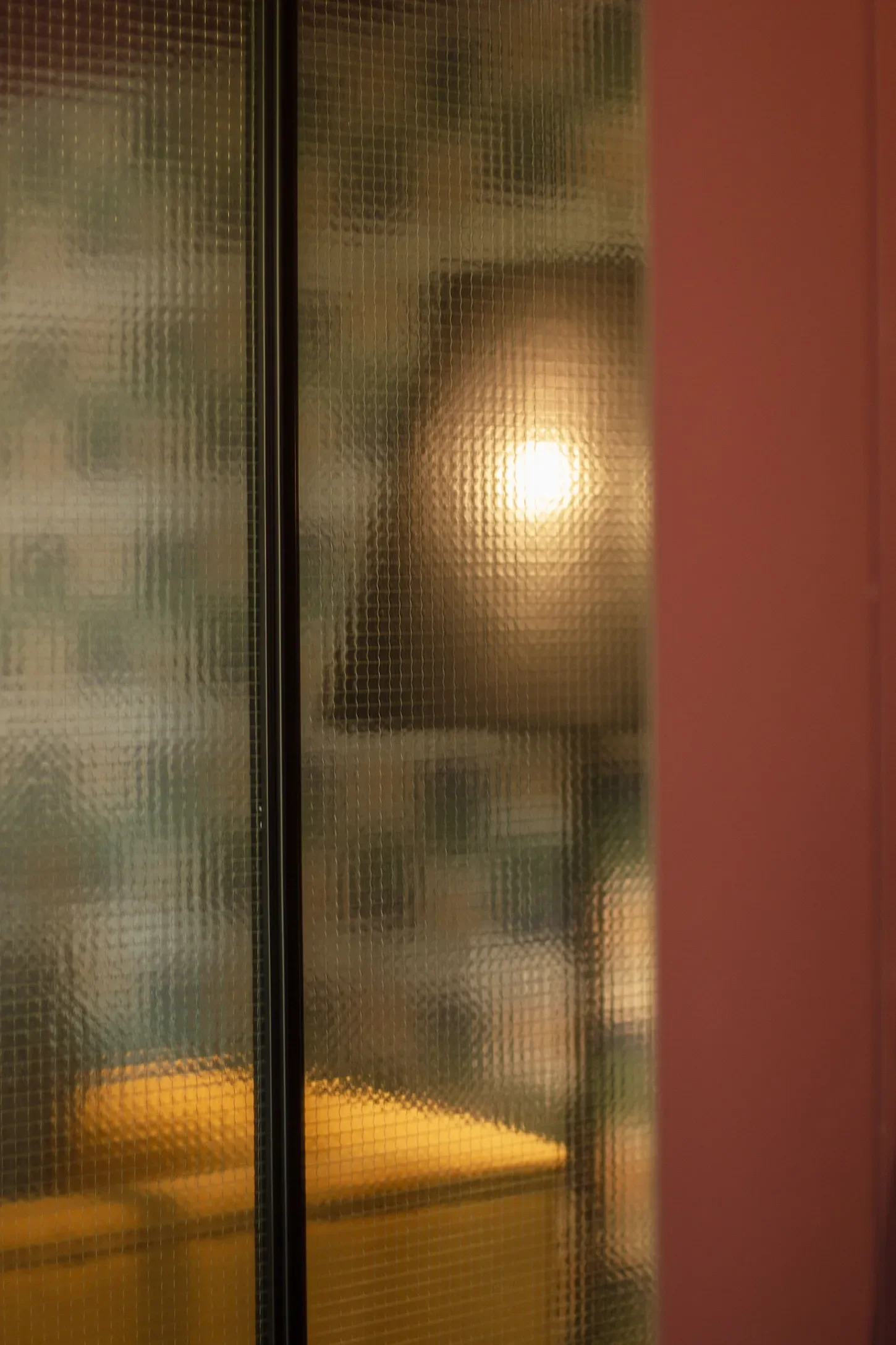 Une verrière sablée apporte un jeu de transparence et de lumière tamisée. Ambiance intime et chaleureuse avec ses couleurs terracotta.