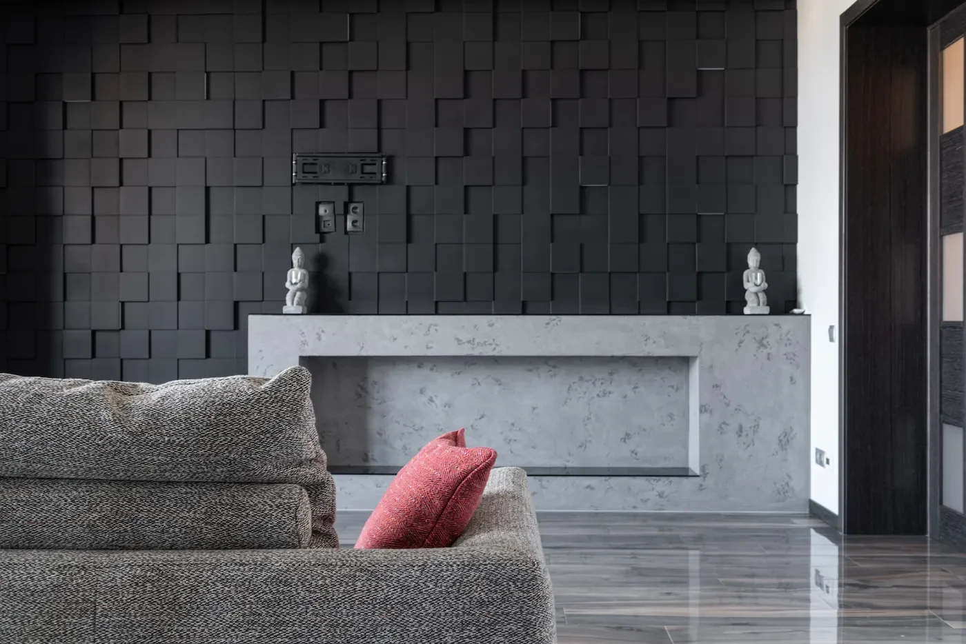 Salon moderne avec mur noir texturé, cheminée en marbre. Ambiance moderne, minérale et contrastée.
