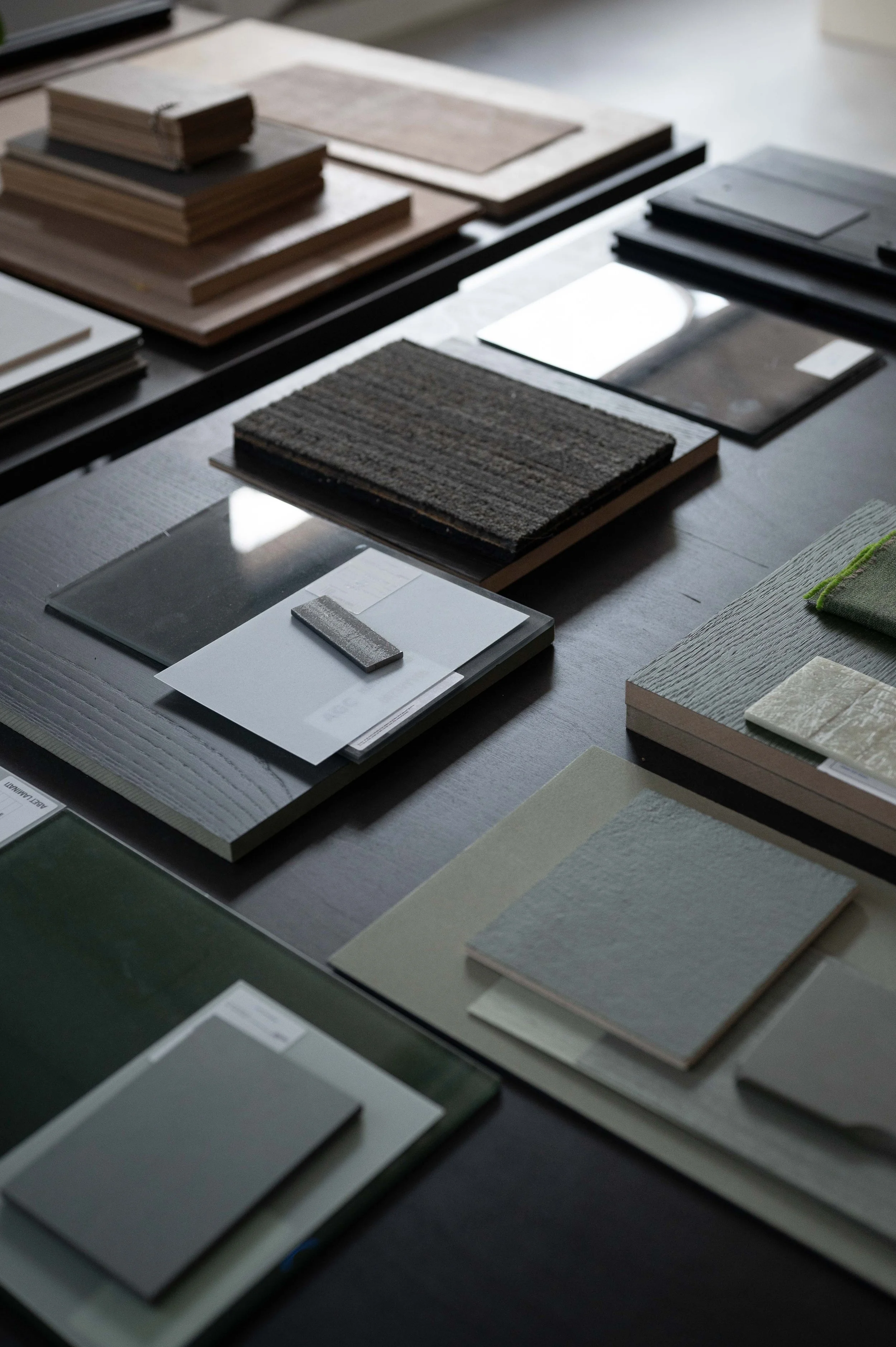 Color samples and material swatches laid out on a table, with various textures and shades used for design or interior decorating.