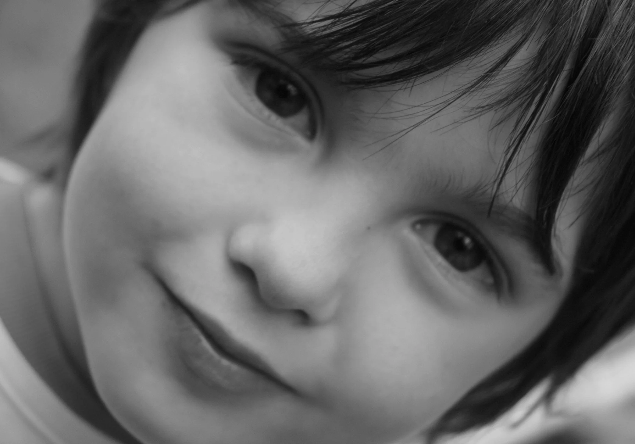 Primo piano di un volto di bambina, occhi grandi e profondi, in bianco e nero.