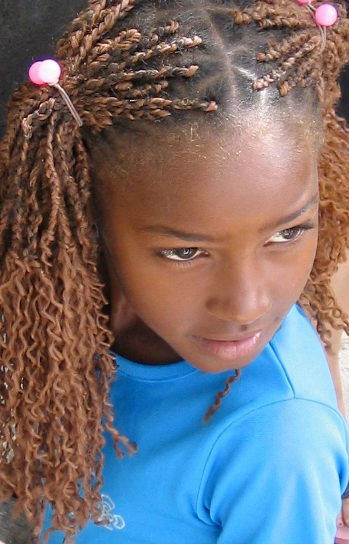 Ragazza con treccine di capelli castani e abbigliamento blu, vista frontale