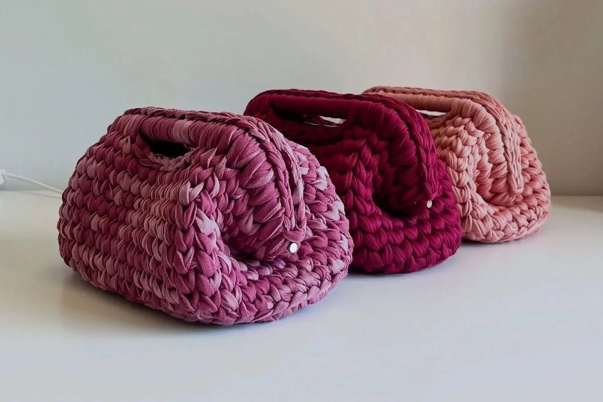 Tre borse di stoffa colorate, in tonalità di rosa e rosso