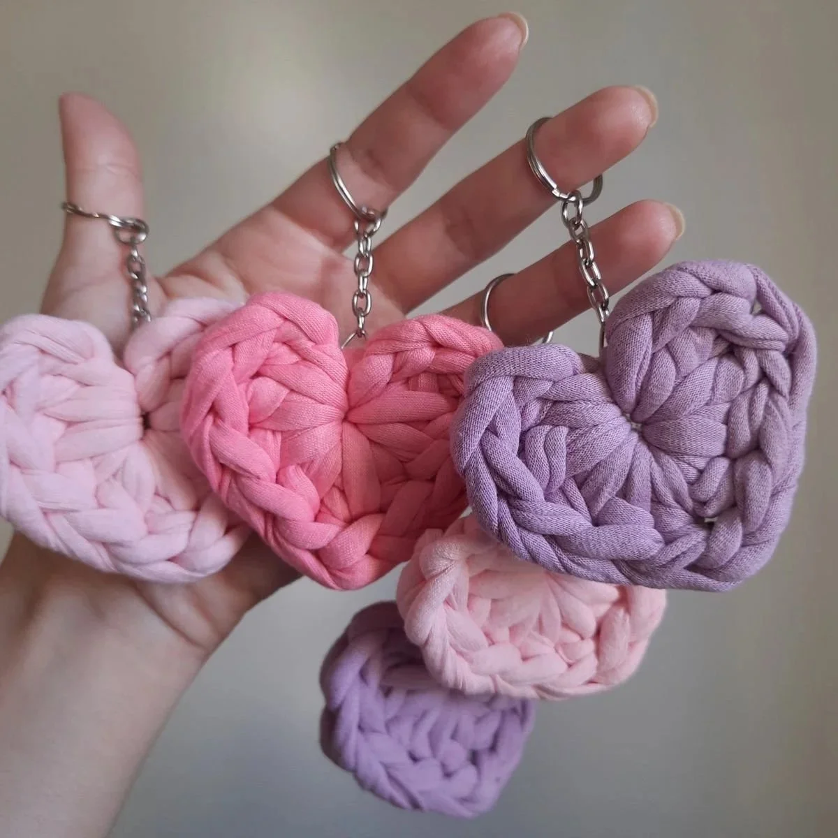 Cuore di stoffa rosa, viola, e lilla con catene di metallo