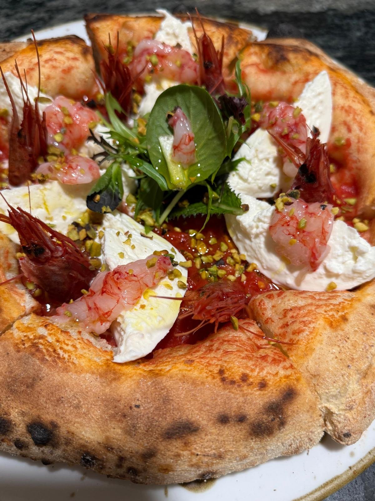 Pizza con gamberetti, mozzarella, pomodoro e basilico.