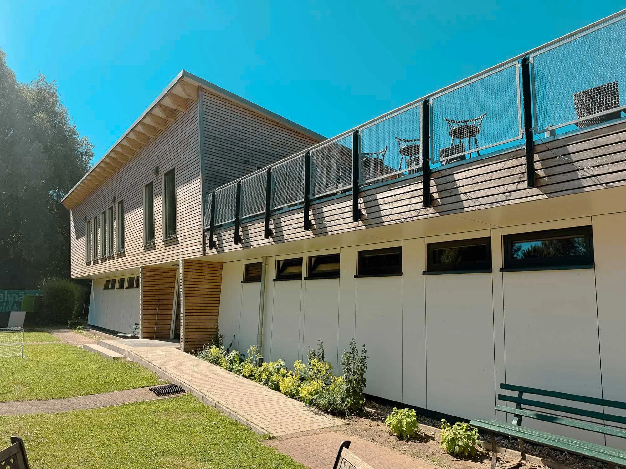 Modernes Vereinsheim des Tennisclubs in Schwerin mit Holzfassade, Dachterrasse und nachhaltiger Neubauarchitektur nach Planung von Kingerske.