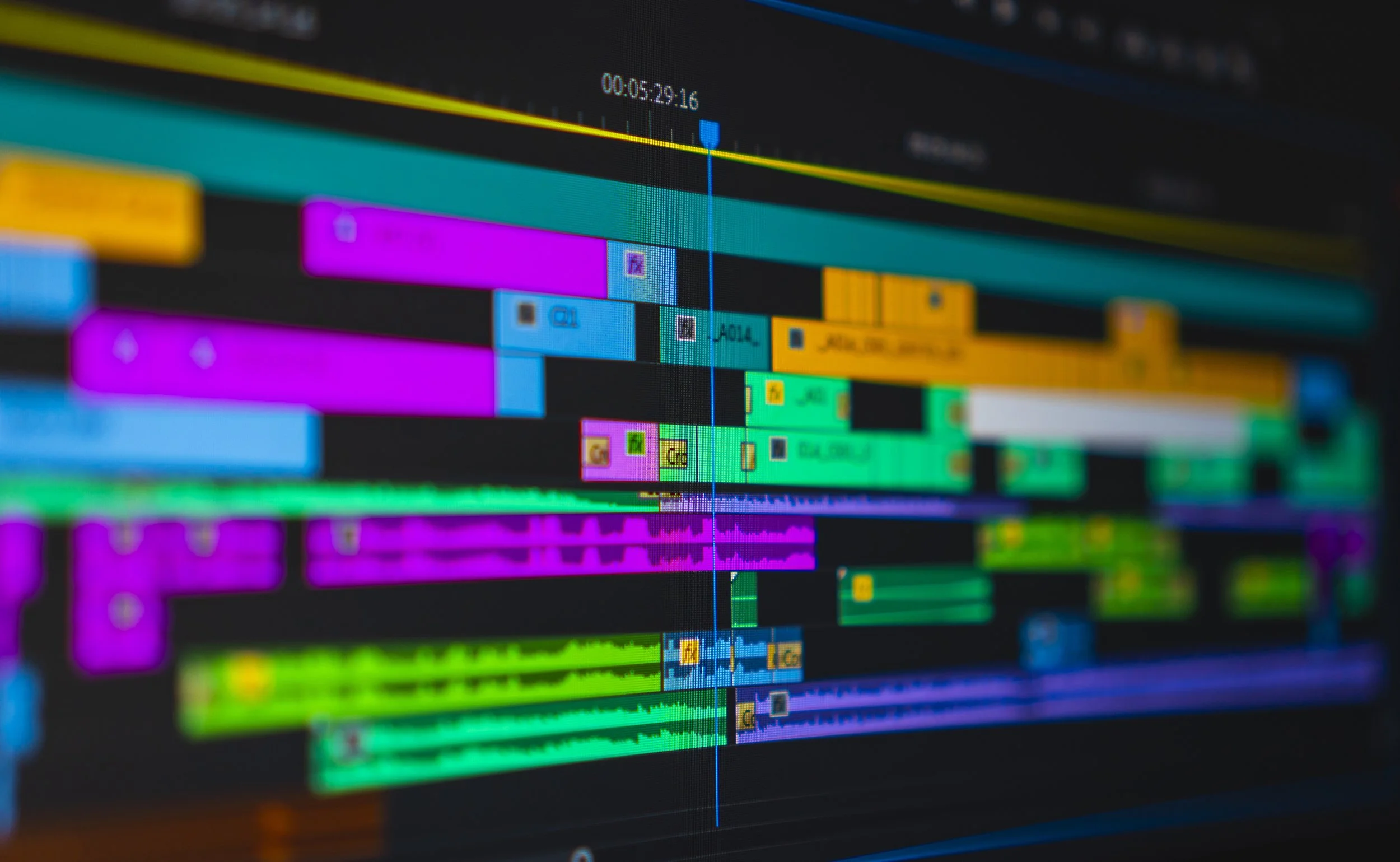 A digital video editing timeline displayed on a computer screen with colorful tracks representing different media clips.