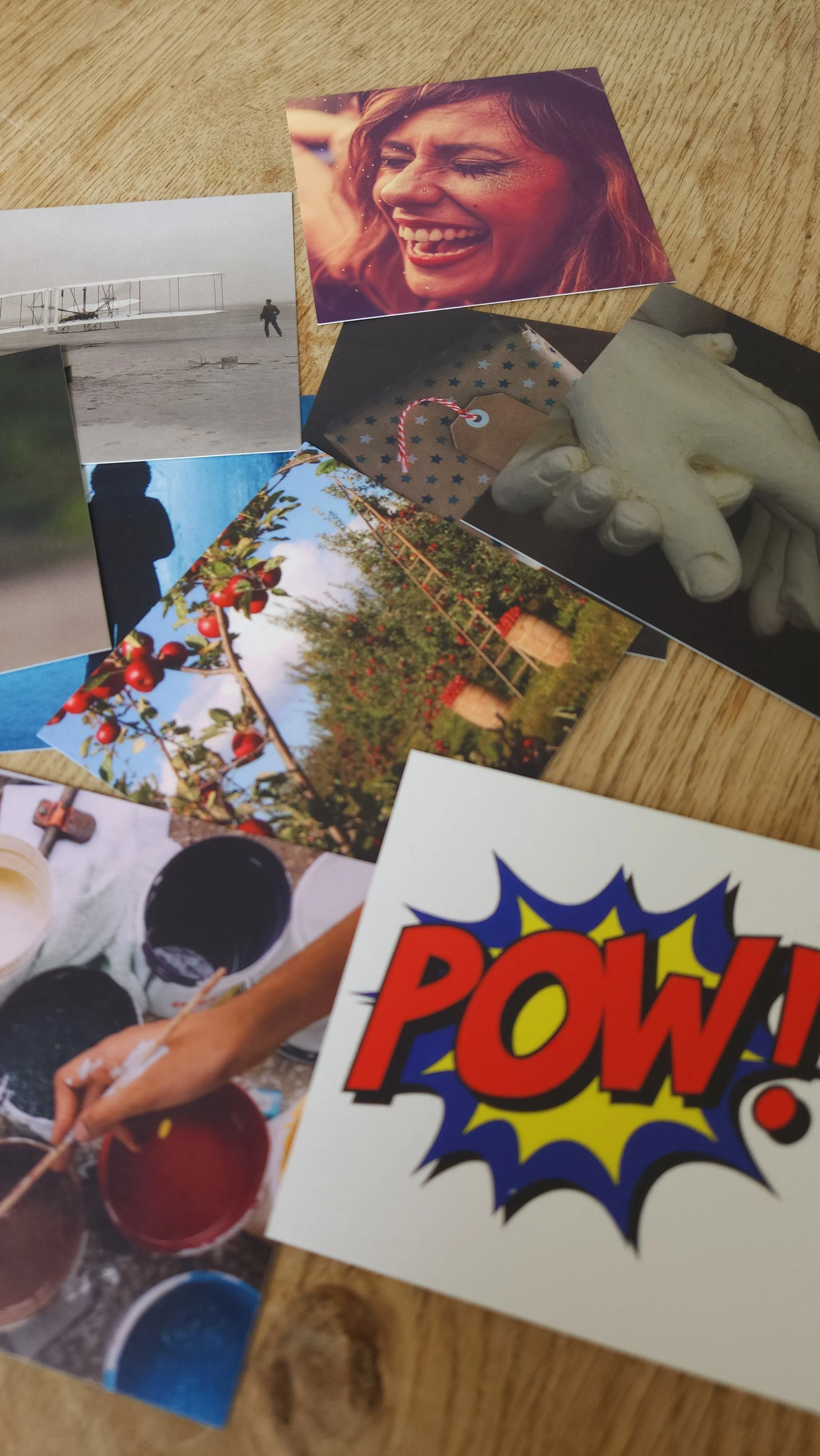 A collection of photographs and art, including a smiling woman, a person walking near an airplane, apples on a tree, a hand holding a paintbrush, and a comic-style "POW!" graphic with vibrant colors.