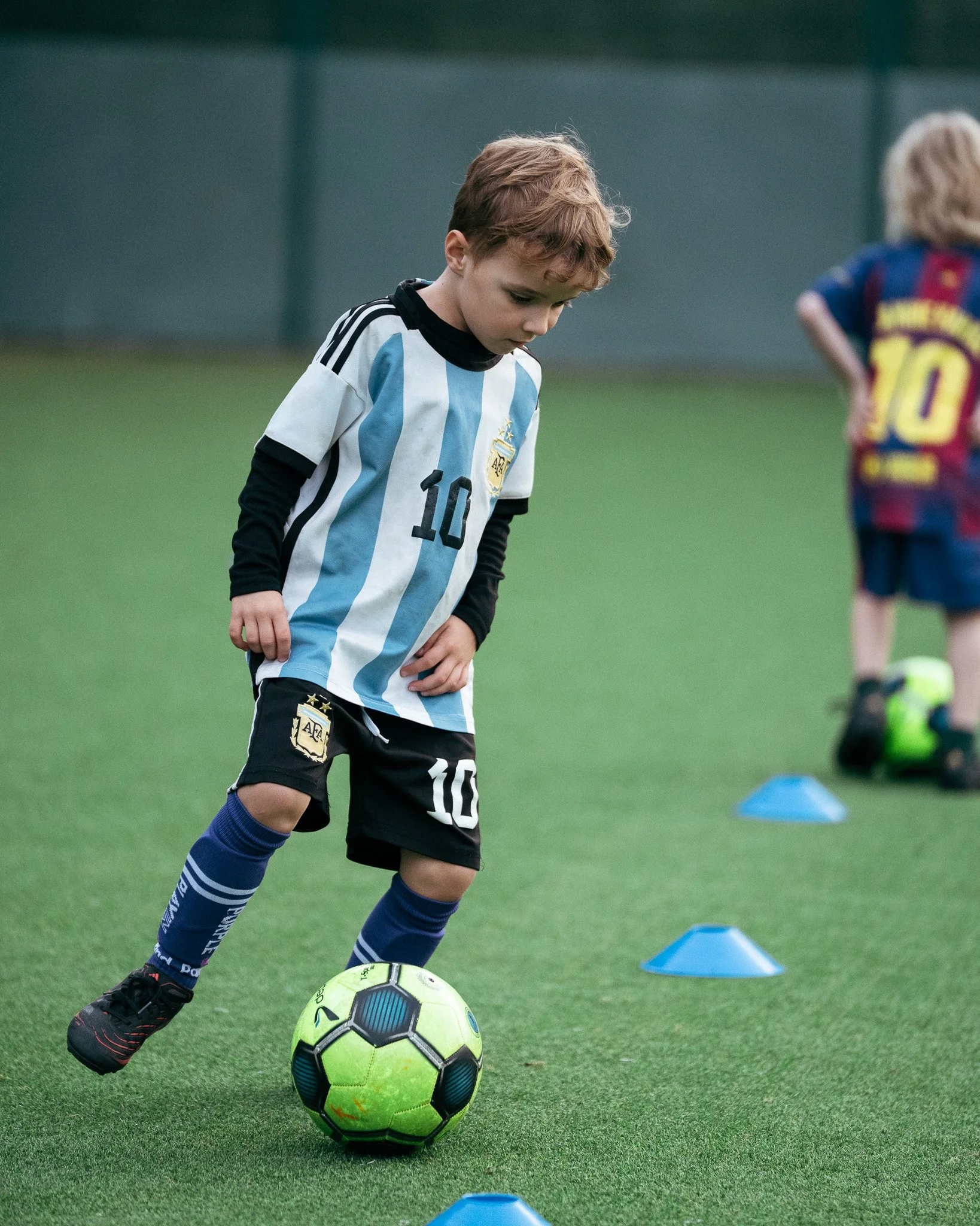 Young football player practising dribbling and ball control during a KB Football Academy training session.