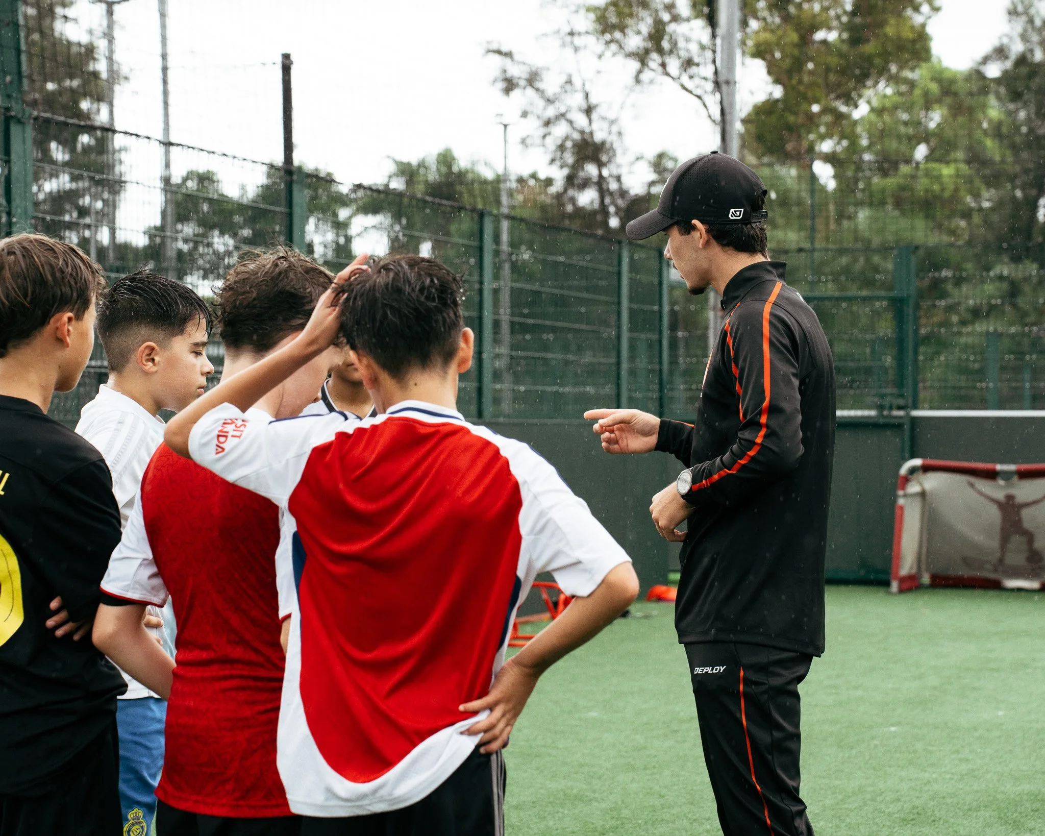 KB Football Academy coach providing individual feedback to young players during football training.