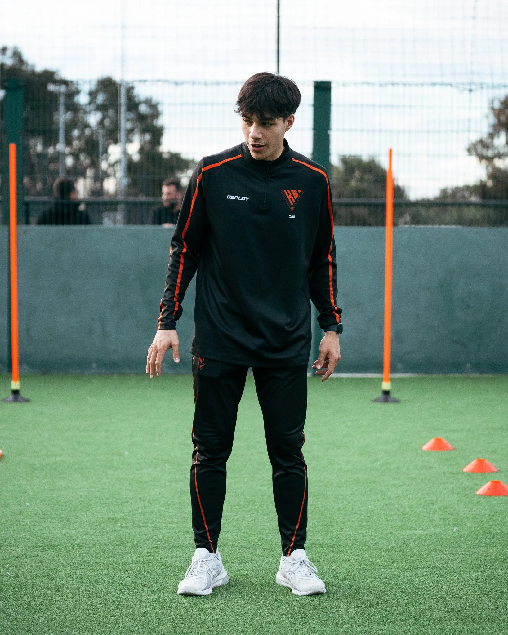 Football coach setting up a training exercise for young players at KB Football Academy.