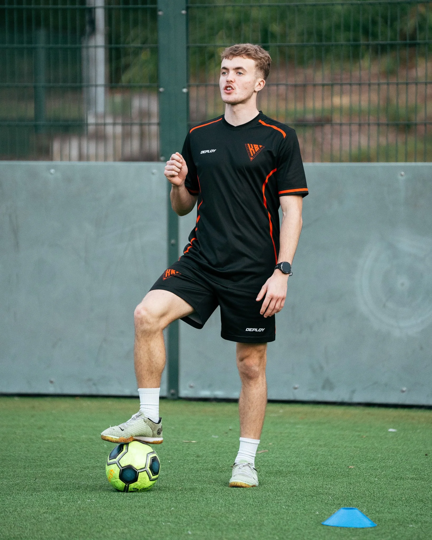 Football coach demonstrating a ball control exercise during a KB Football Academy training session.