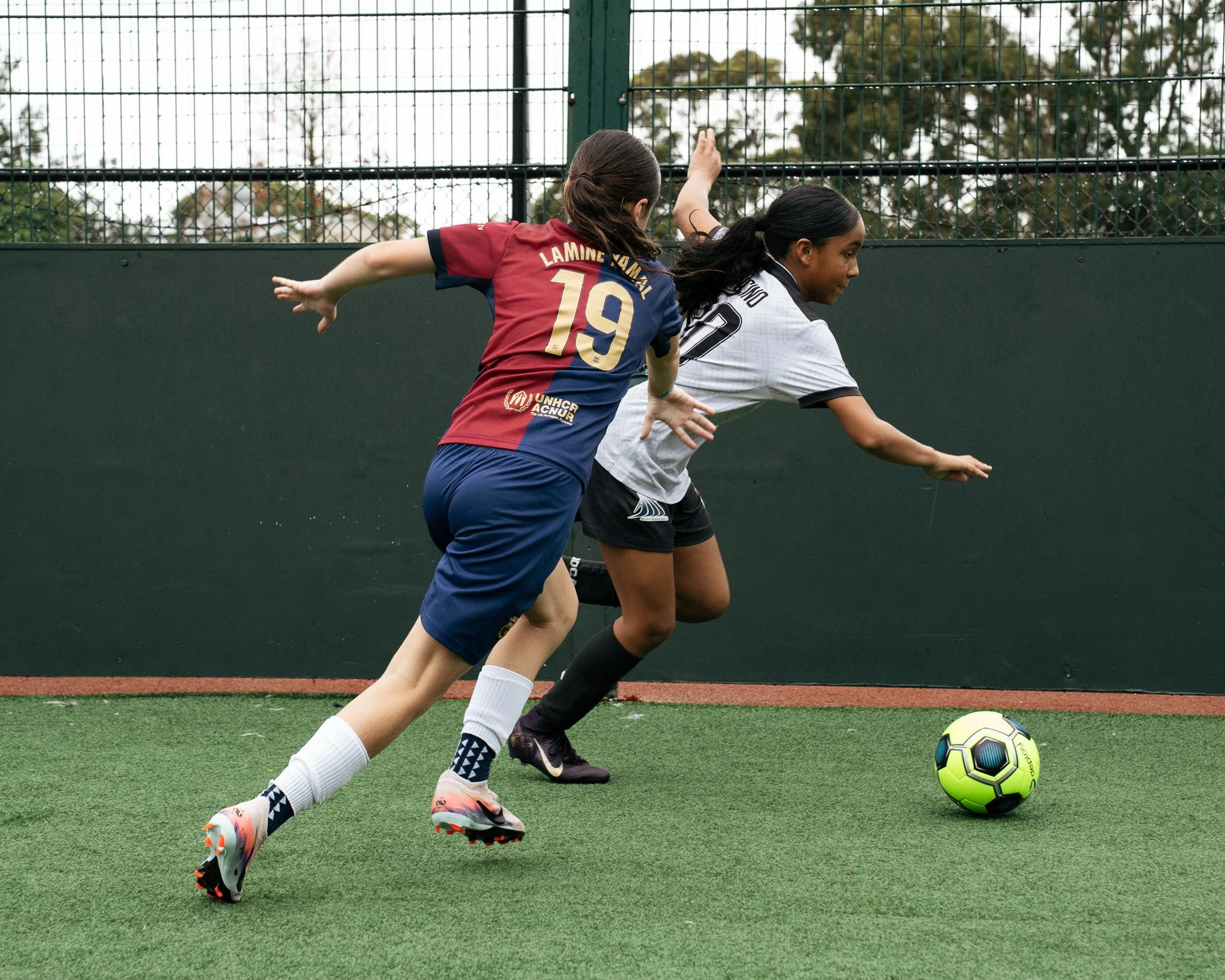 Two football players competing for the ball during a 1v1 training exercise at KB Football Academy.