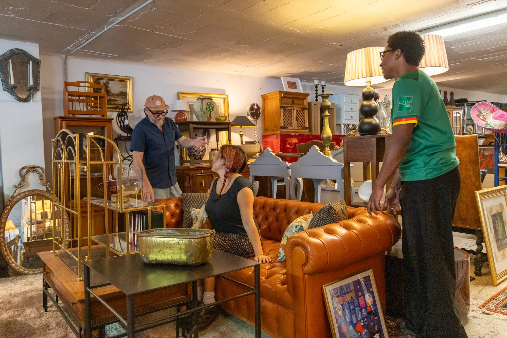 People shopping at a vintage furniture store, viewing various antique and decorative items. Aymerick Rondeau Furniture Emporium Alhaurin second hand furniture shop