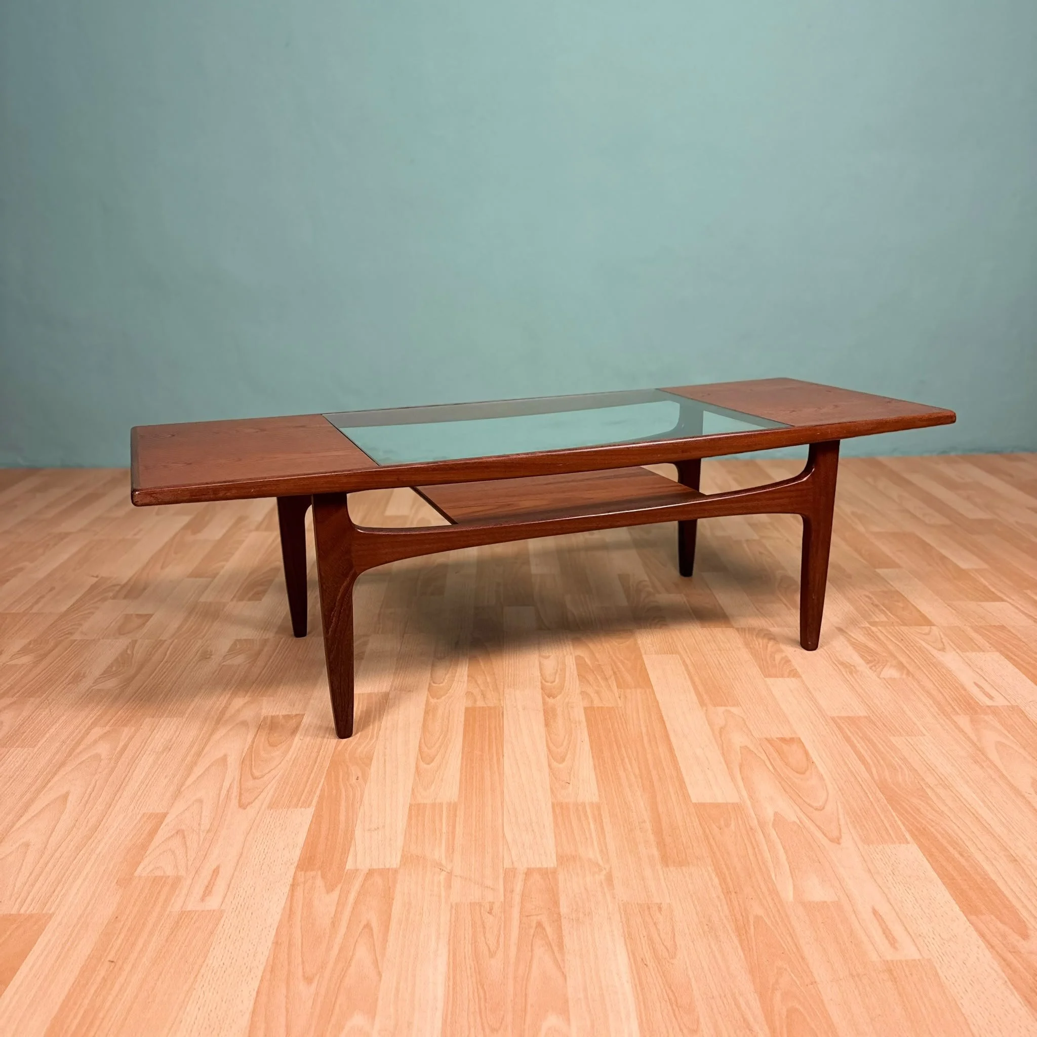 Empty wooden table with a glass top in a room with a light green wall and wooden floor. Aymerick Rondeau Furniture Emporium Alhaurin second hand furniture shop