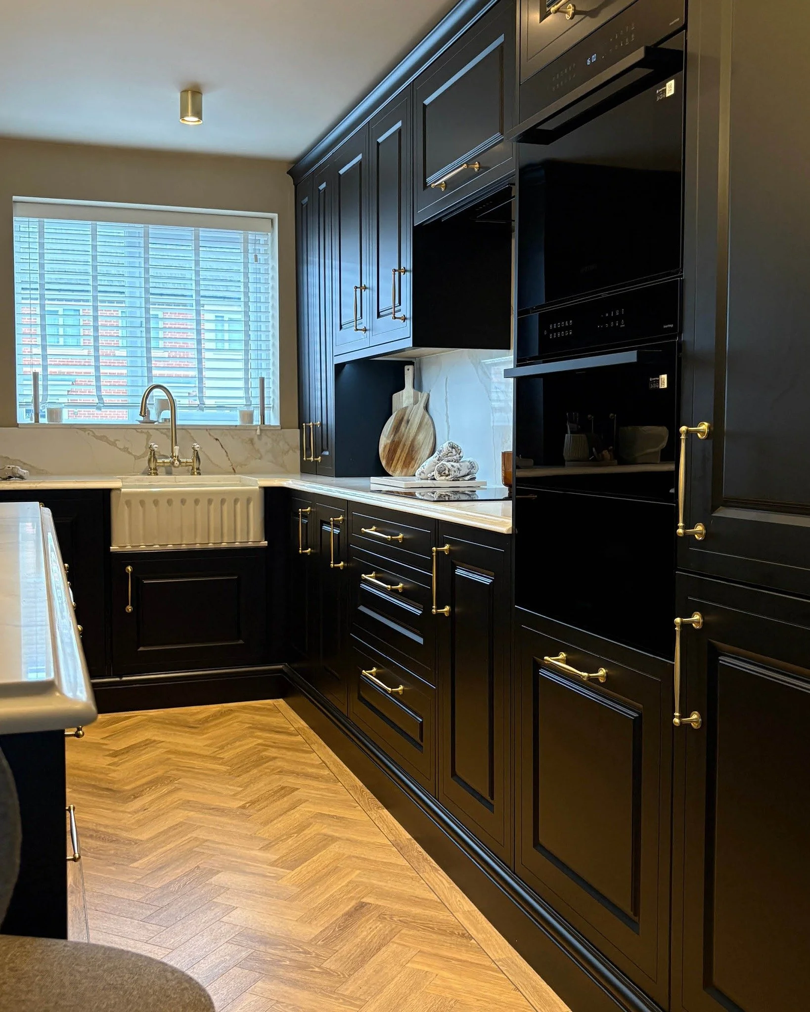 Proof that a dark kitchen can still feel warm.

Matt black cabinetry, brushed brass handles and a warm-toned quartz worktop. There&rsquo;s also a breakfast cabinet that keeps the coffee supplies, toaster and morning clutter tucked away until they&rsq