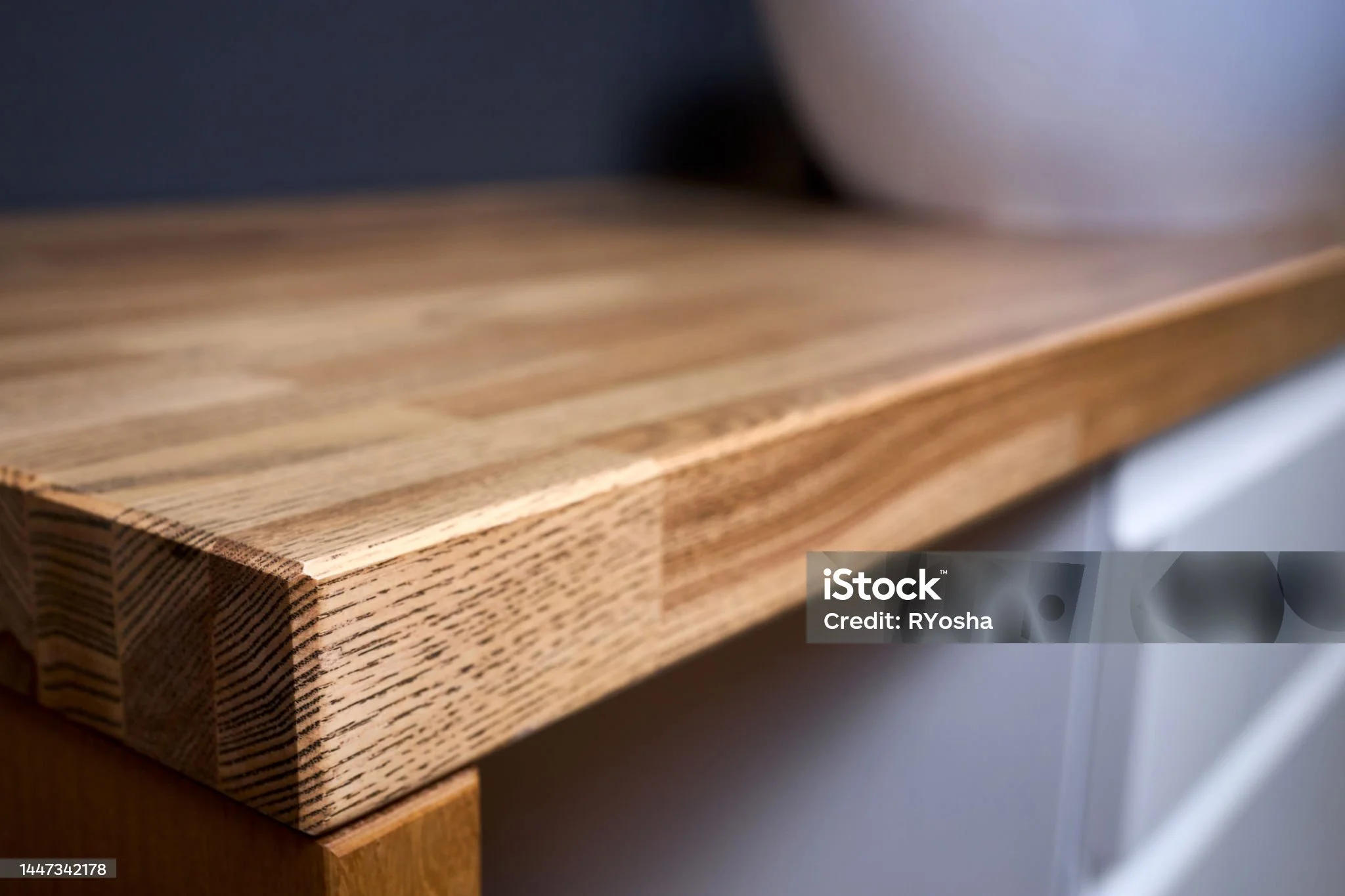 Close-up of a wooden table or furniture with a smooth surface and visible wood grain details.