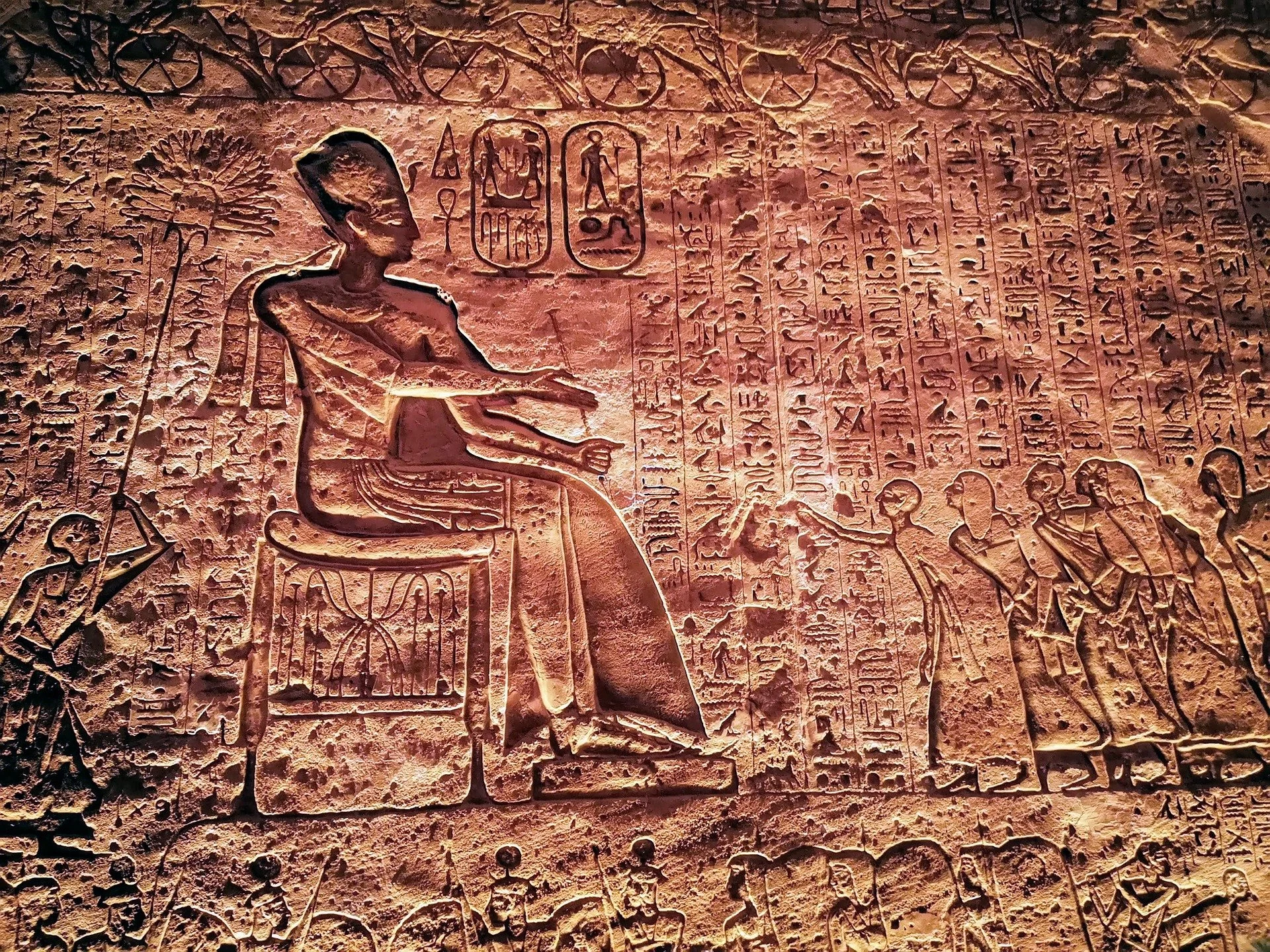 Incisioni geroglifiche egiziane raffiguranti divinità e figure umane su una parete di pietra