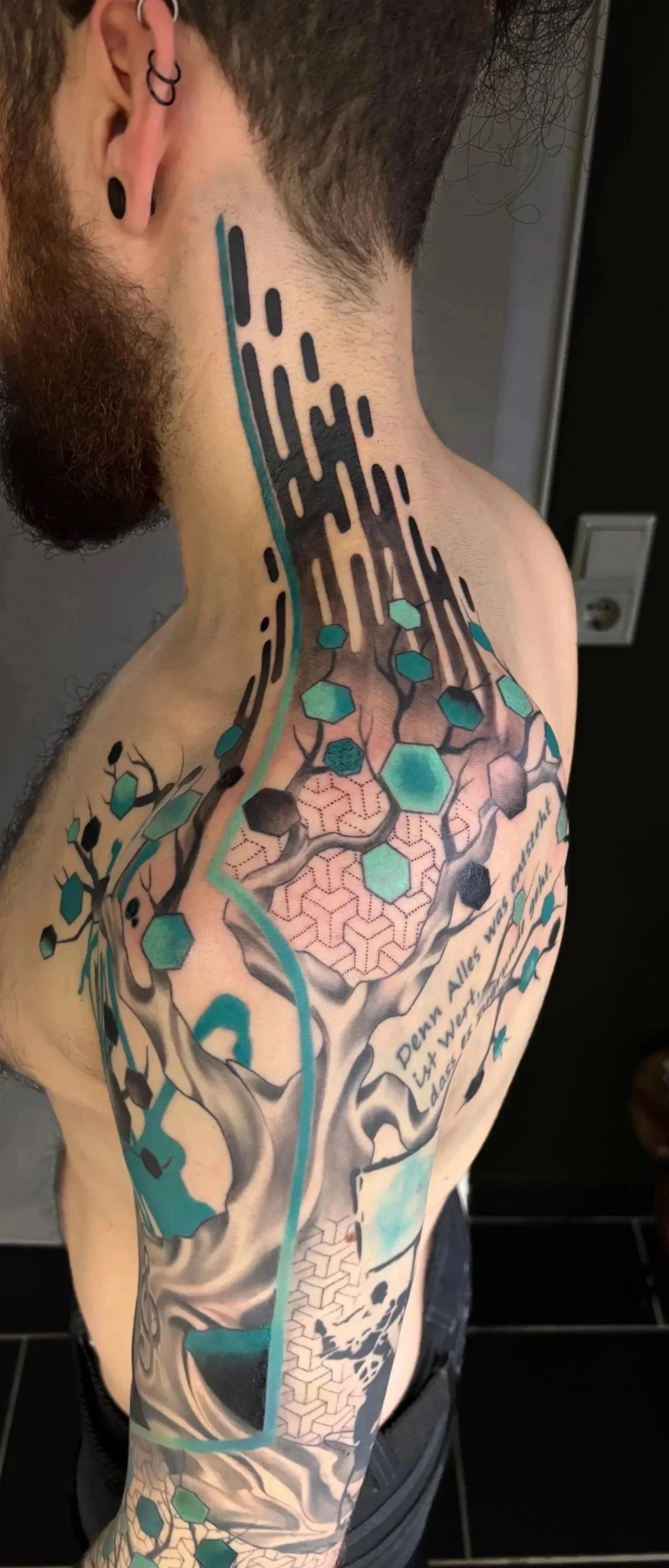A detailed tattoo of a neural network and geometric patterns on a person's shoulder and upper arm.