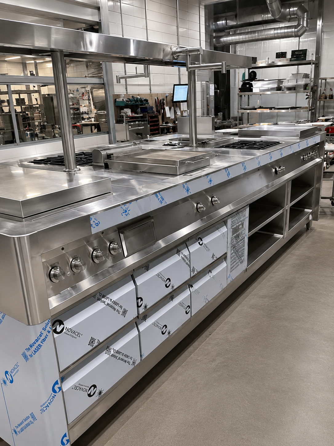 Estufa industrial de acero inoxidable europeas  en una cocina profesional. Tiene fogones, una plancha y espacio de almacenamiento debajo.