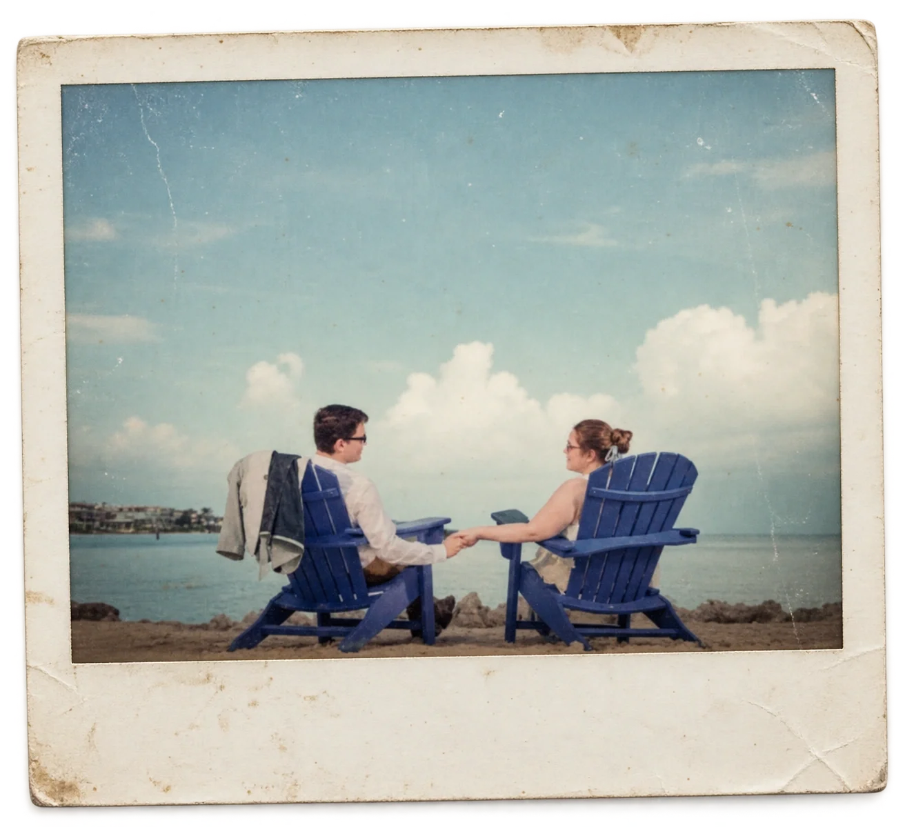 Couple holding hands in blue Adirondack chairs overlooking the water in Florida, photographed by River Branch Adventure Co.