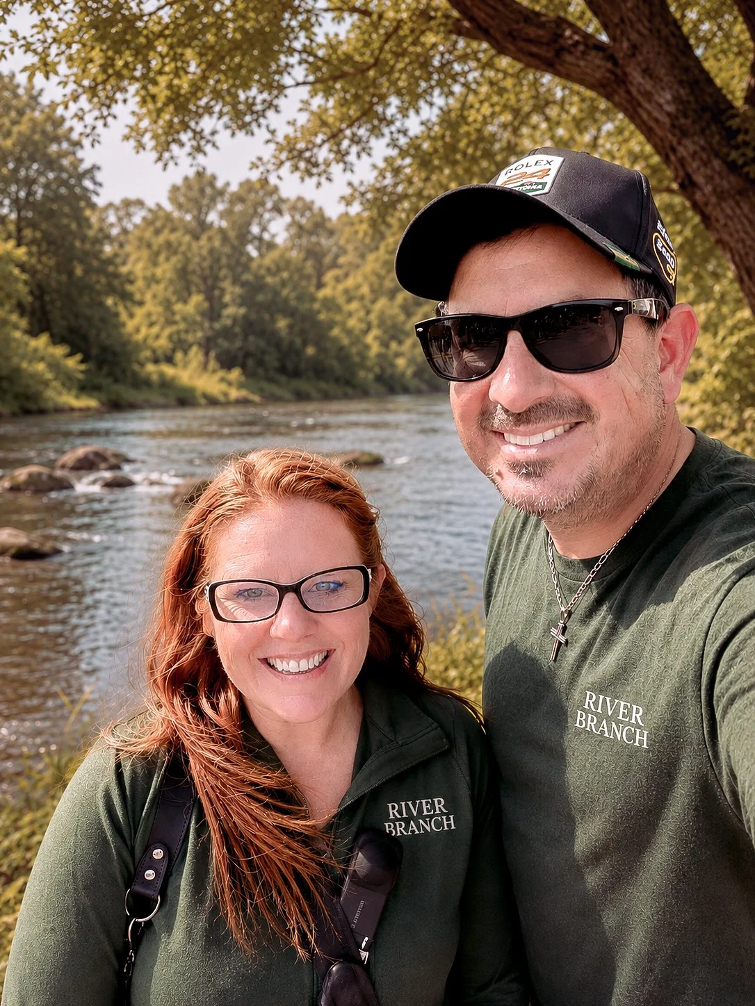 DeShawna and Mike standing beside a river surrounded by nature, representing the connection and adventure that inspired River Branch Adventure Co.