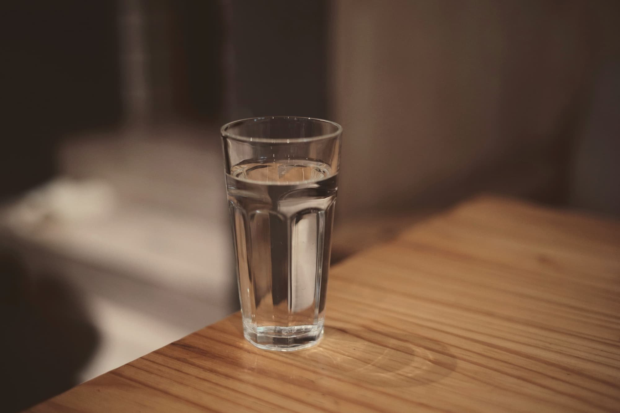 An untouched glass of water on a bedside table