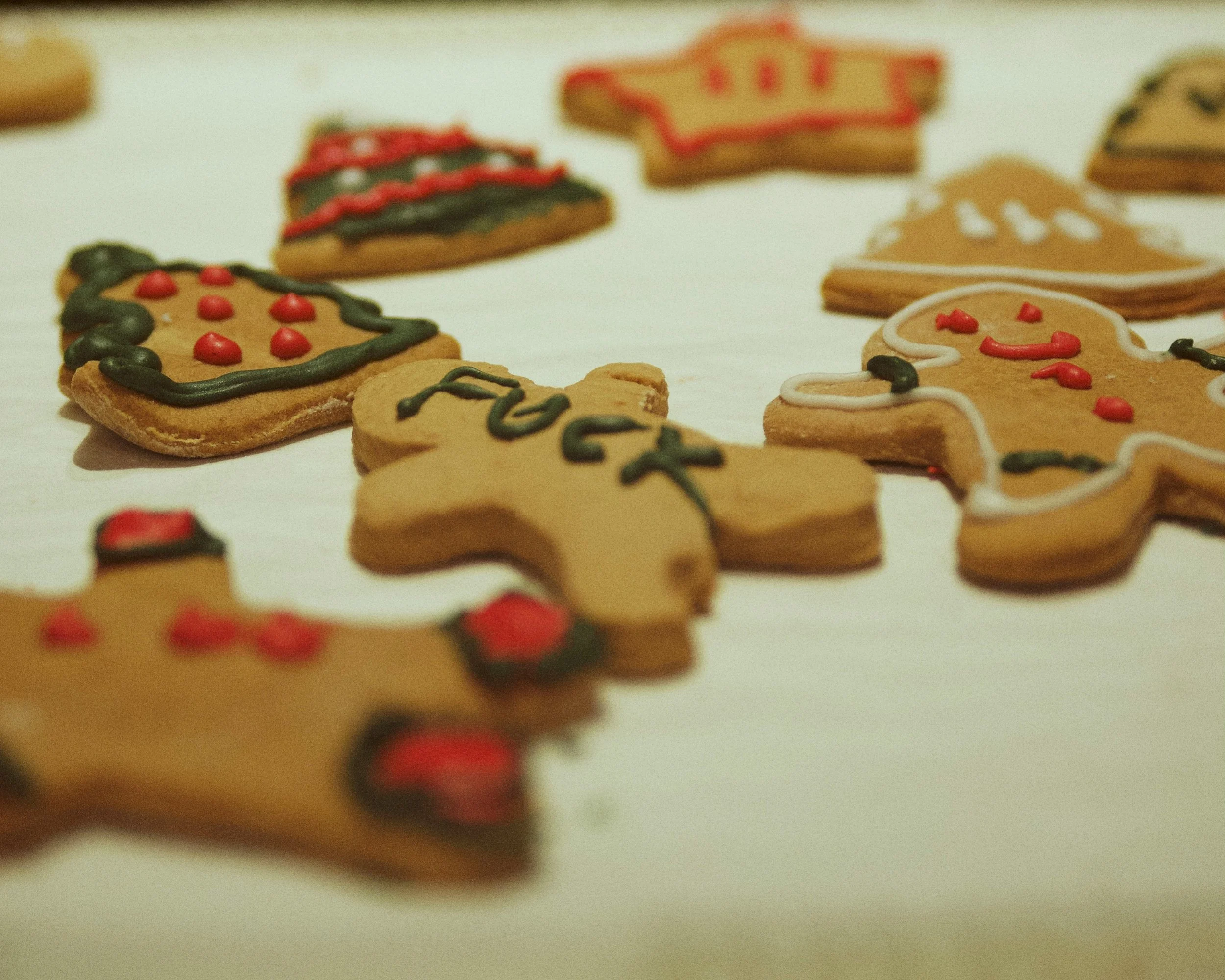 Iced Christmas biscuits, one with a swear word written on it in green icing