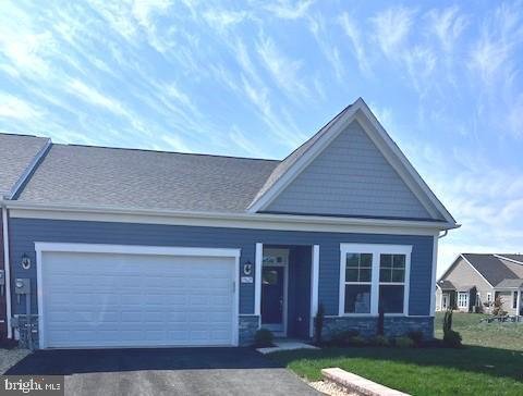 Blue house with white trim, attached garage, front lawn, and blue sky with scattered clouds.