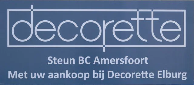Een blauwe bordenmet wit tekst die reclame maakt voor Decorette, steun voor BC Amersfoort en een boodschap om bij Decorette Elburg te kopen.