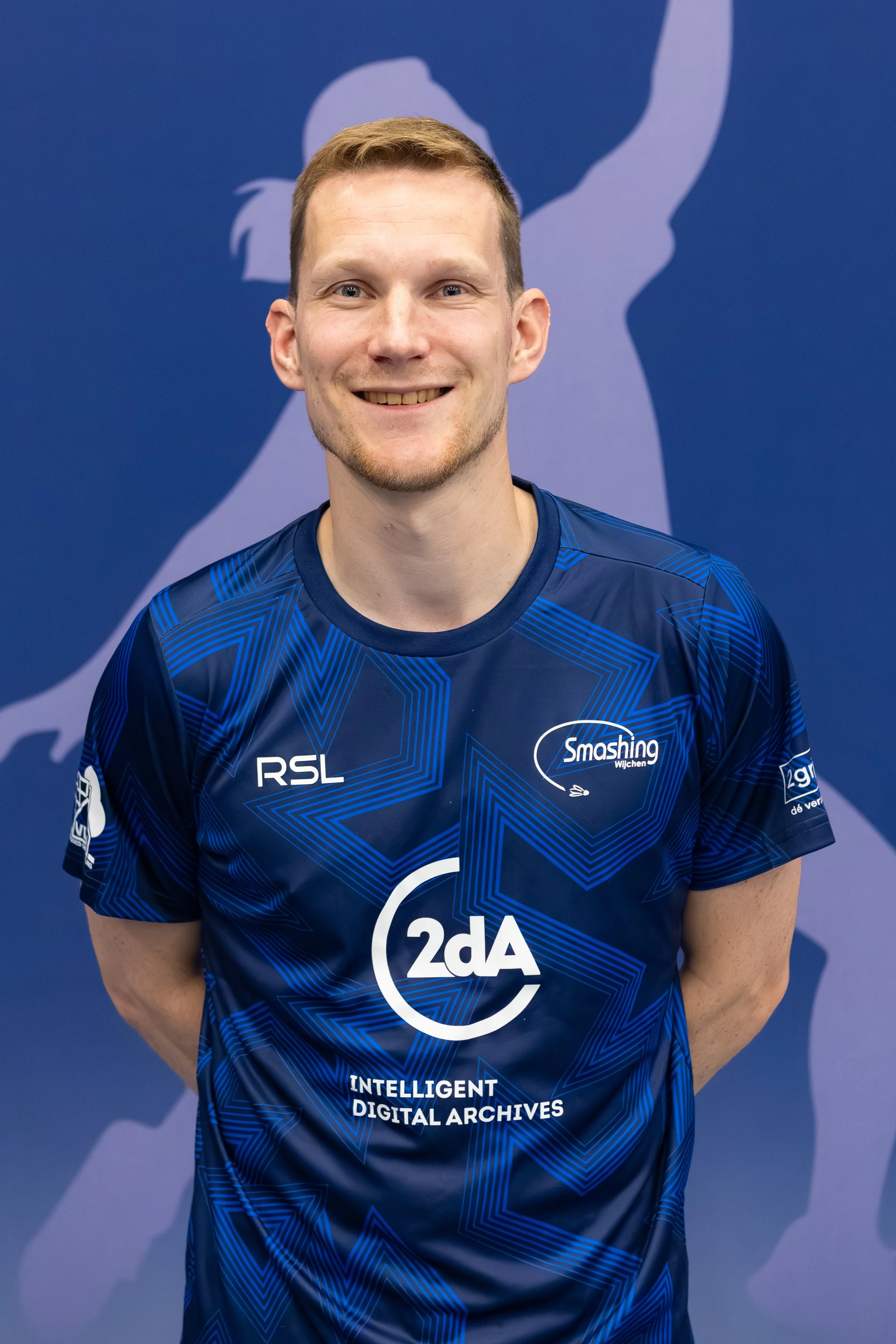 Badmintonner Robin Tabeling in zijn BC Smashing clubshirt voor een fabric achterwand