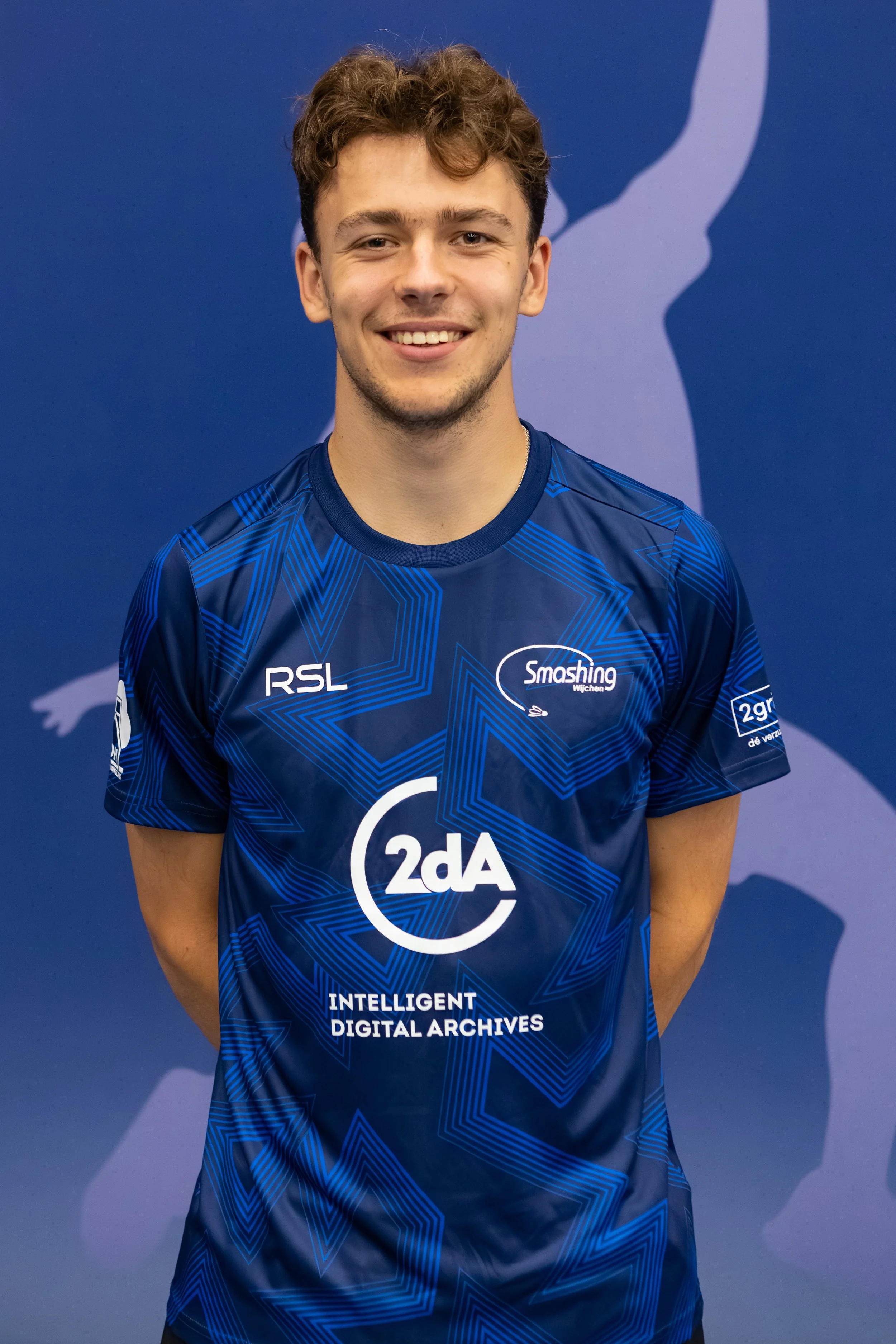 Badmintonner Casper Spaans in zijn BC Smashing clubshirt voor een fabric achterwand