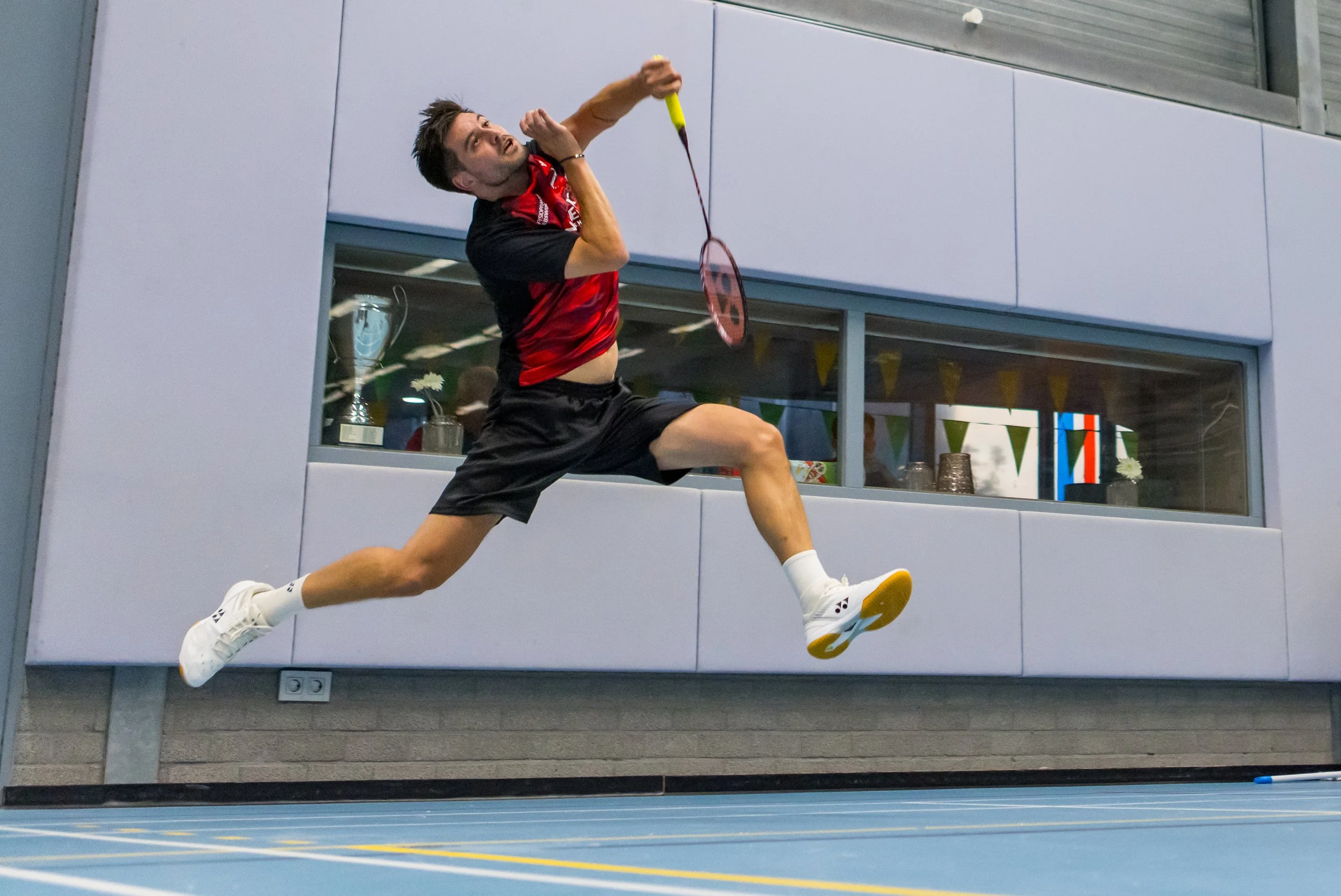 Nick Fransman doet een sprong op een indoor sportvloer, mogelijk tijdens een wedstrijd of training.