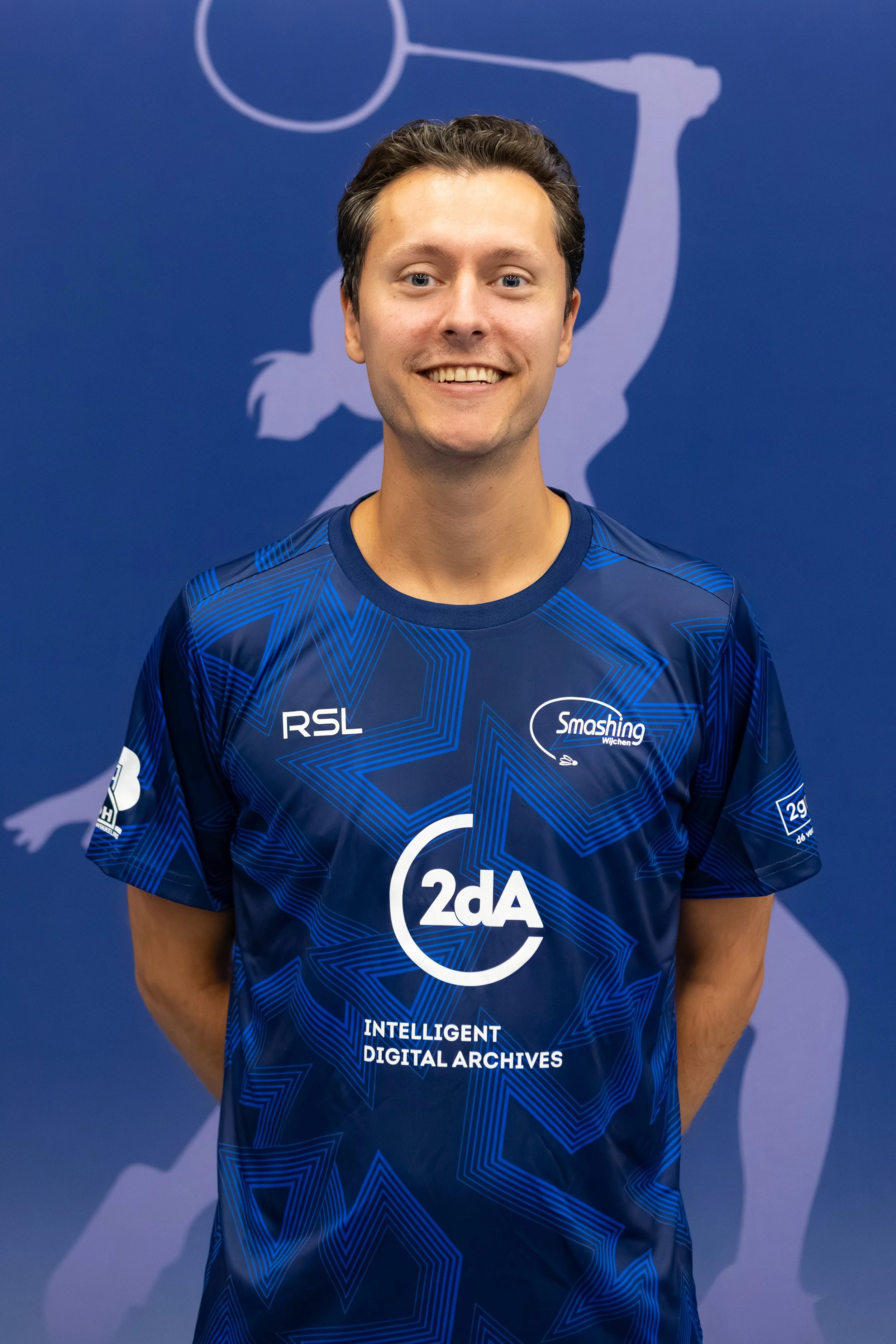 Badmintonner Vincent de Vries in zijn BC Smashing clubshirt voor een fabric achterwand