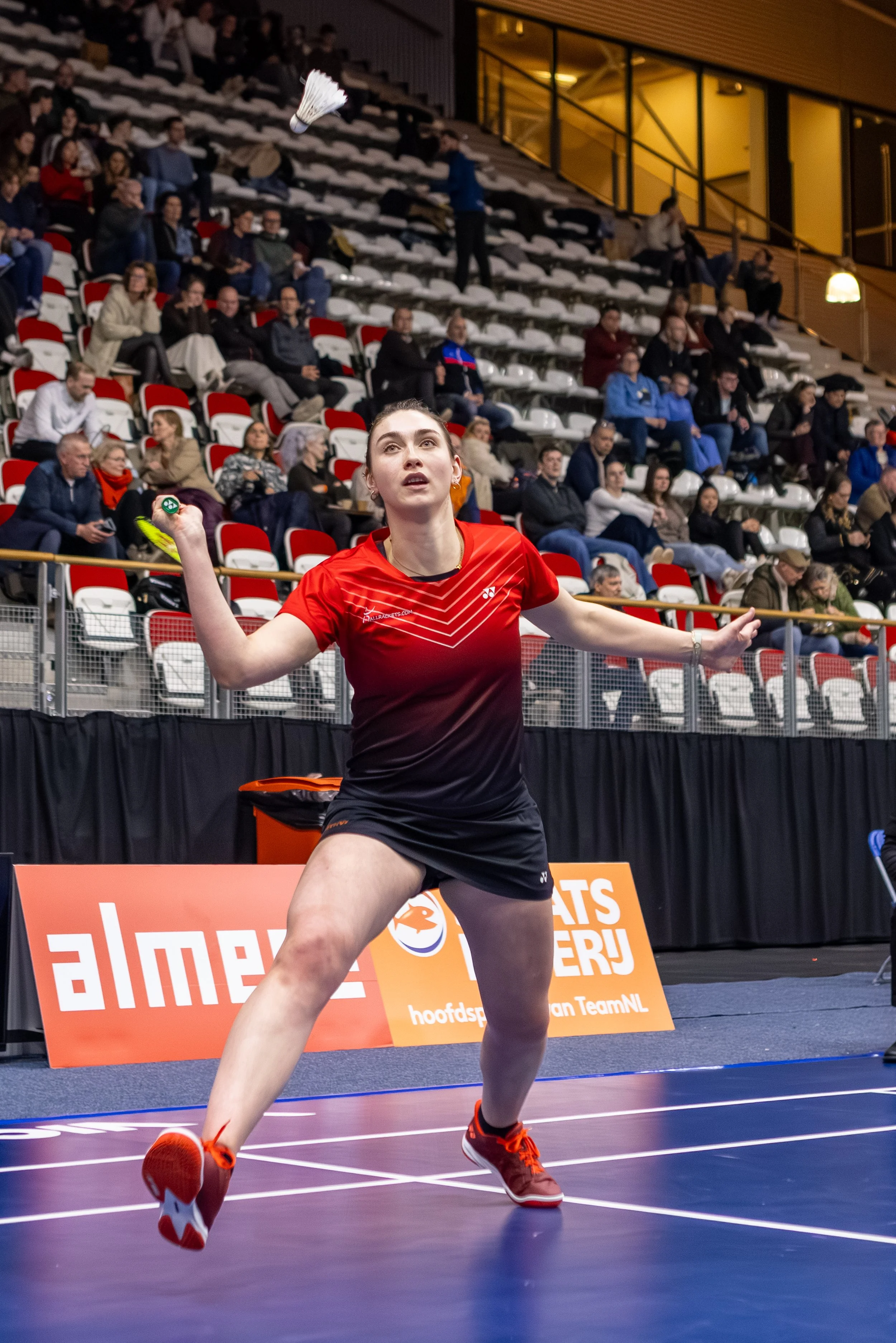 Imke van der Aar in actie op een indoor sporthal, met een publiek op de achtergrond.