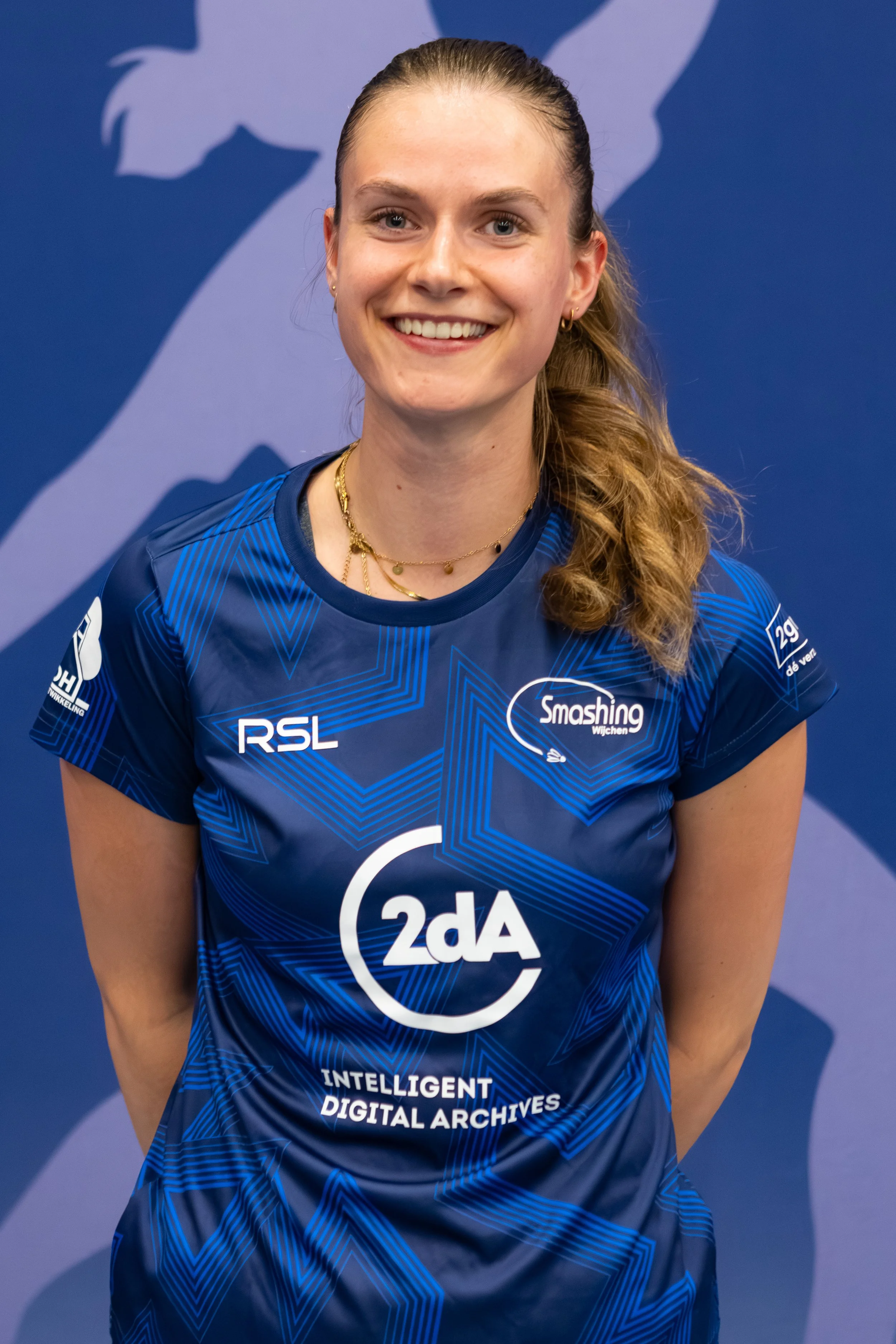 Badmintonner Maureen Zewald in haar BC Smashing clubshirt voor een fabric achterwand