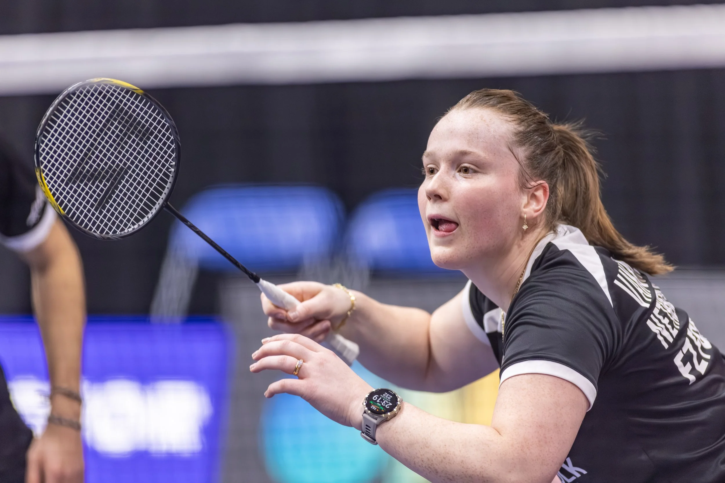Een vrouwelijke tafeltennisspeler die zich voorbereidt om te serveren tijdens een wedstrijd.