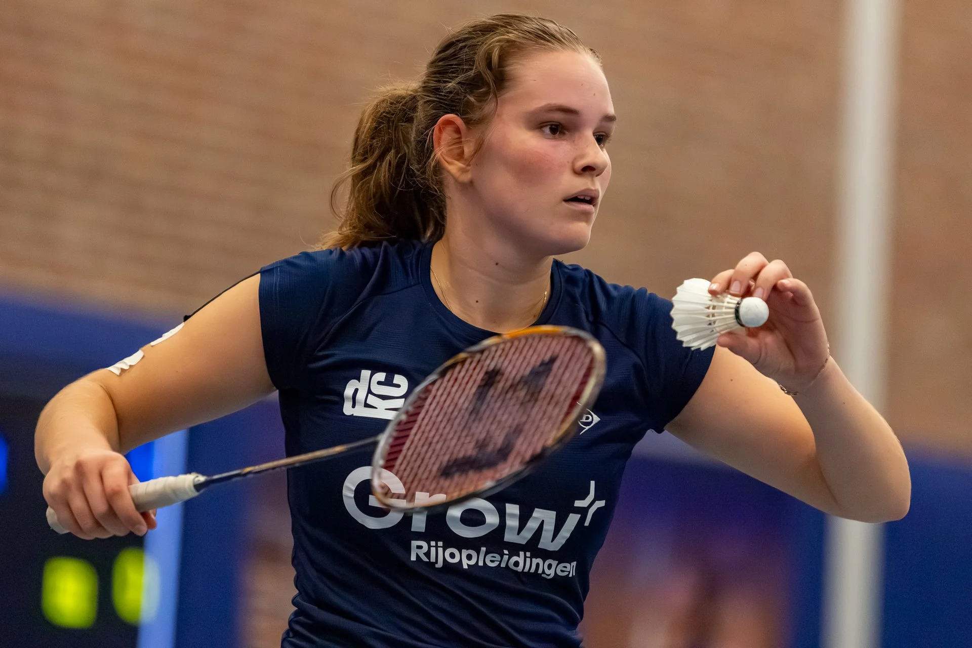 Lieke van Parys met een badmintonracket, op een donkere achtergrond.