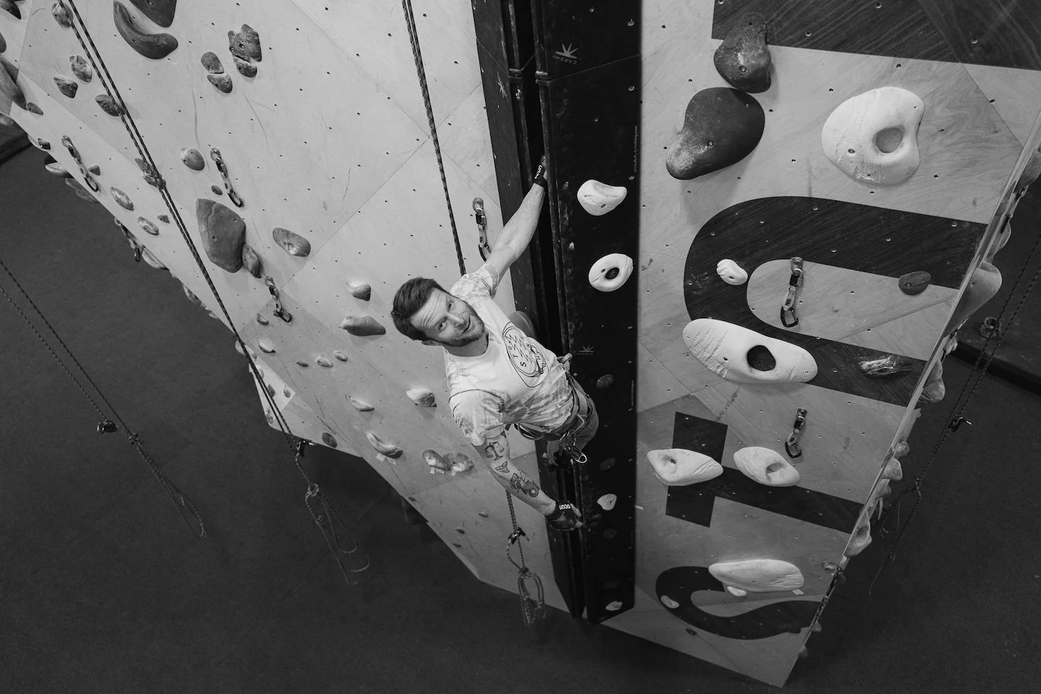 Black and white photo of a climber on a crack climb at an indoor climbing gym