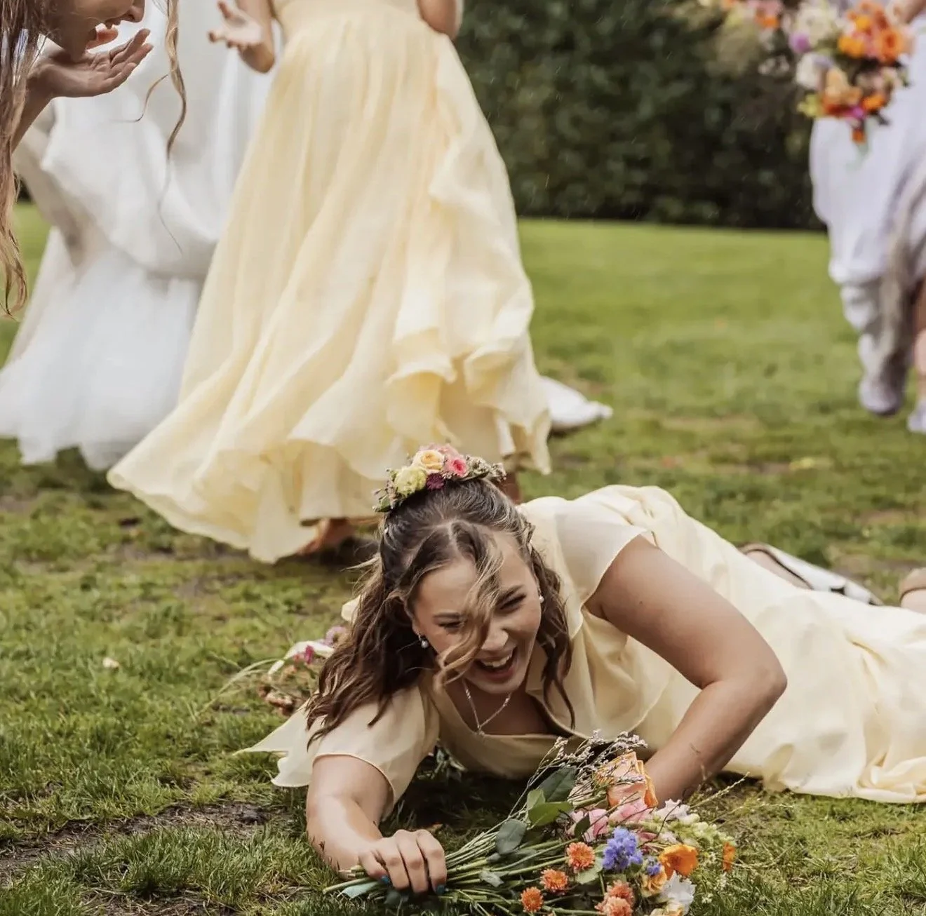 A bridesmaid slipping over with her bouquet on the floor.