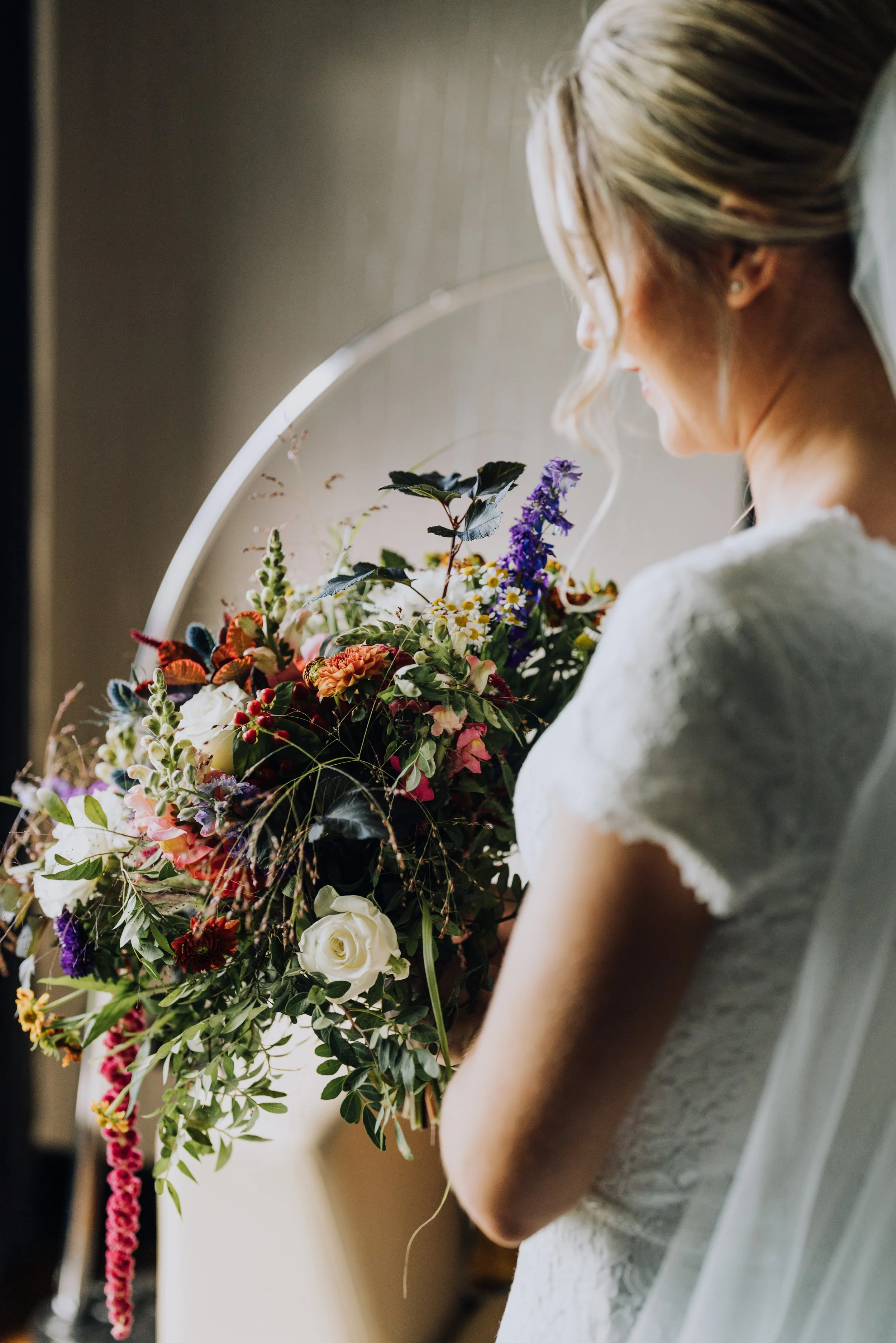 A bride with her back to the camera holding her bridal bouquet