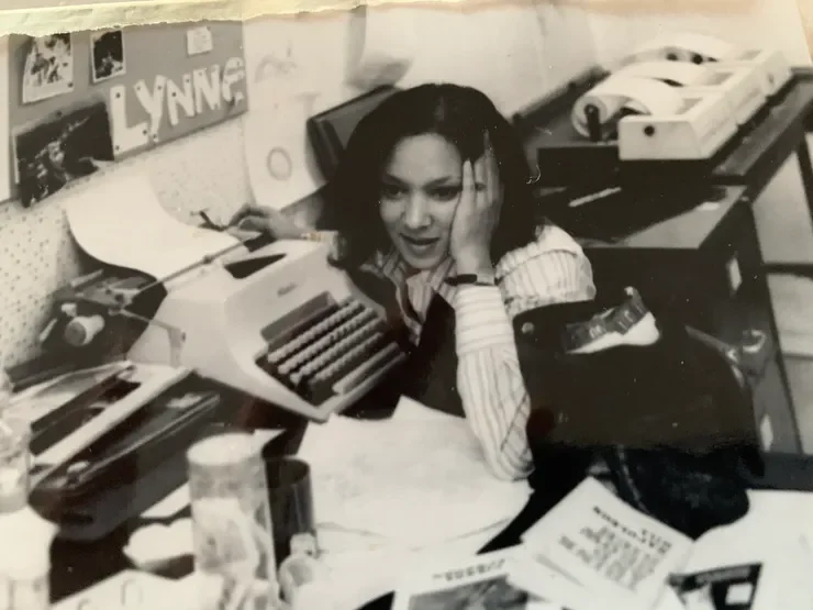 Black and white photograph of Lynne White working at a typewriter during her journalism career