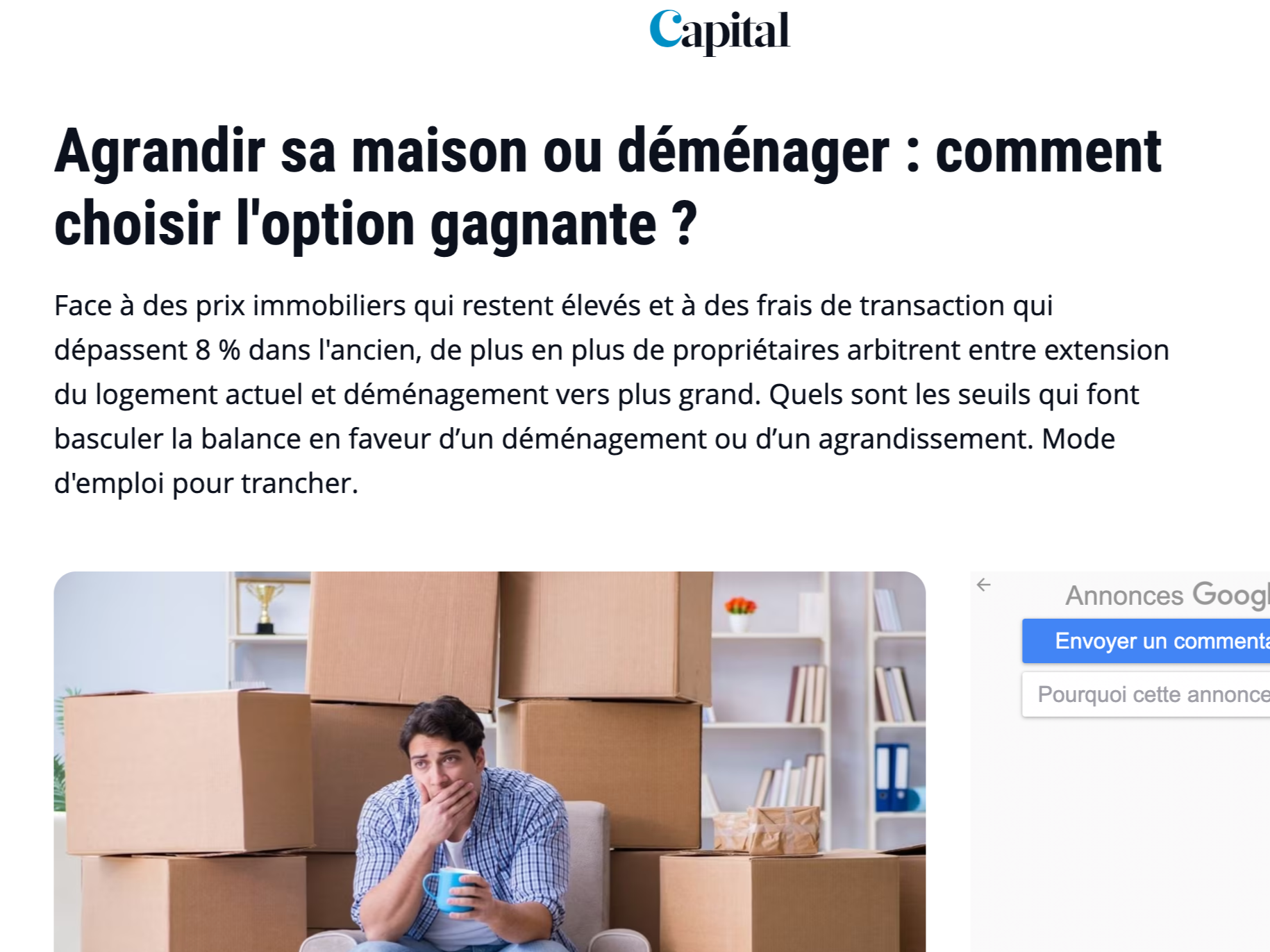 Une jeune homme assis dans une pièce remplie de centaines de cartons en train de réfléchir, tenant une tasse bleue