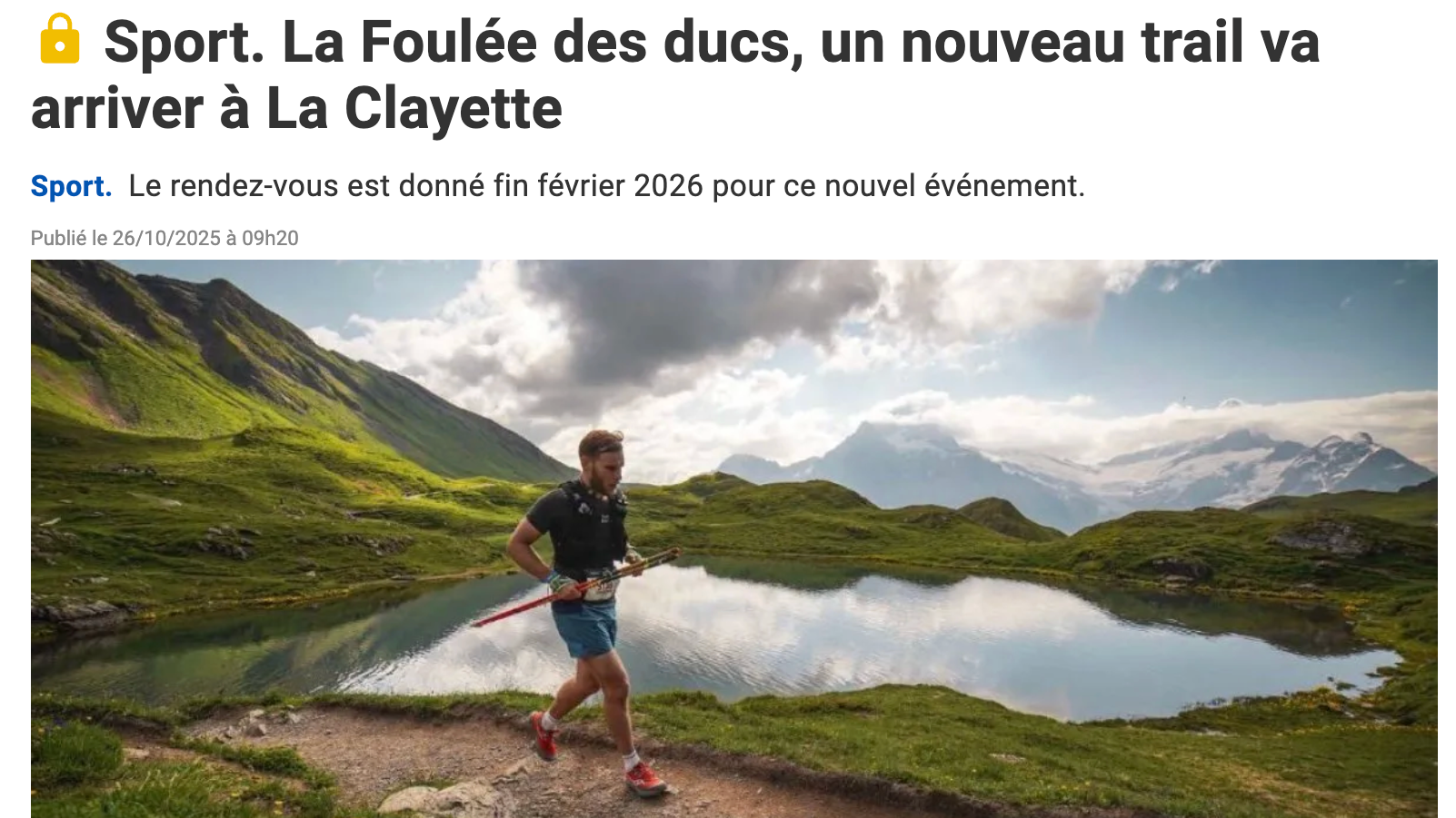 Un homme court sur un sentier de montagne près d'un lac dans un paysage alpin avec des montagnes enneigées à l'arrière-plan, sous un ciel partiellement nuageux.