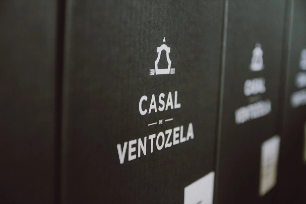 Caixa de embalagem preta com o texto "Casal de Ventozela" em branco, com símbolo de uma torre na parte superior.