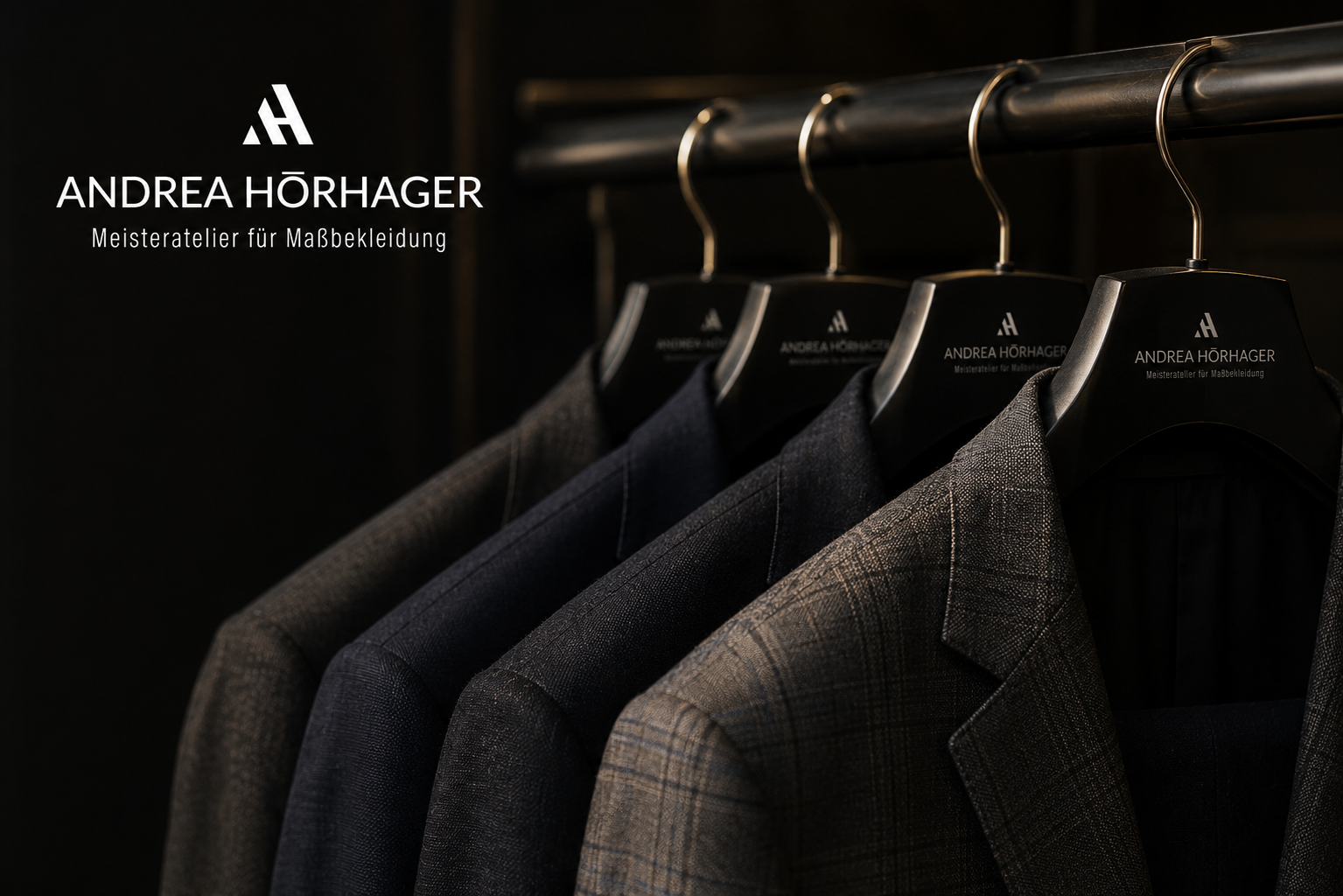 Dreimal leger Tesasten hängen an einer Garderobe. Die Mäntel sind aus kariertem Stoff in verschiedenen Farben. In der oberen linken Ecke befinden sich Logo und Text von Andrea Hörhager, Meisteratelier für Maßkleidung.