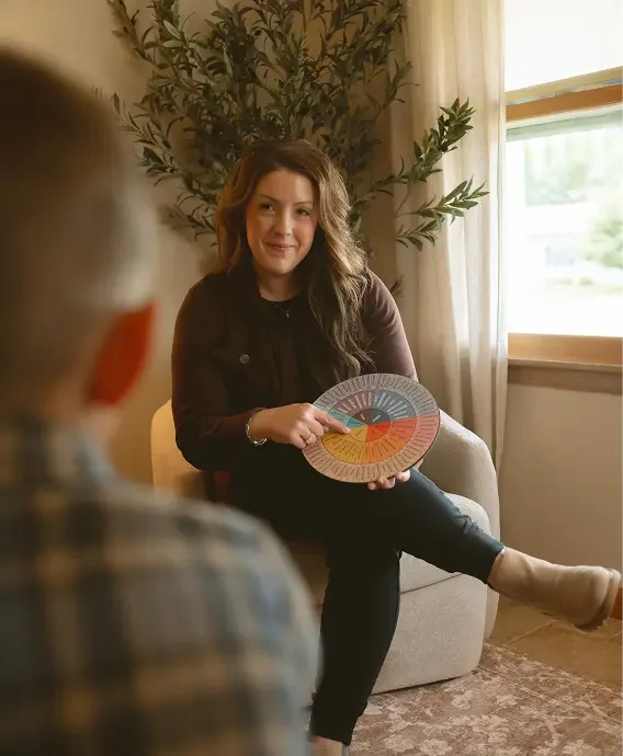 Therapist helping an overextended client name and process unmet emotional needs using a feelings wheel