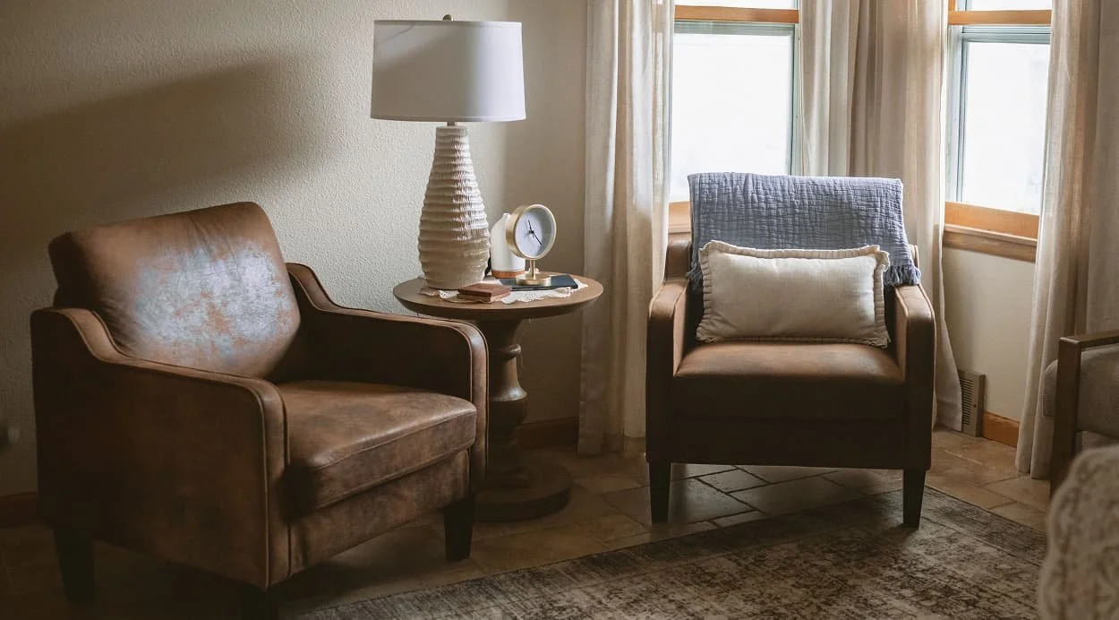 Two leather armchairs facing each other in a warm therapy office at The Haven