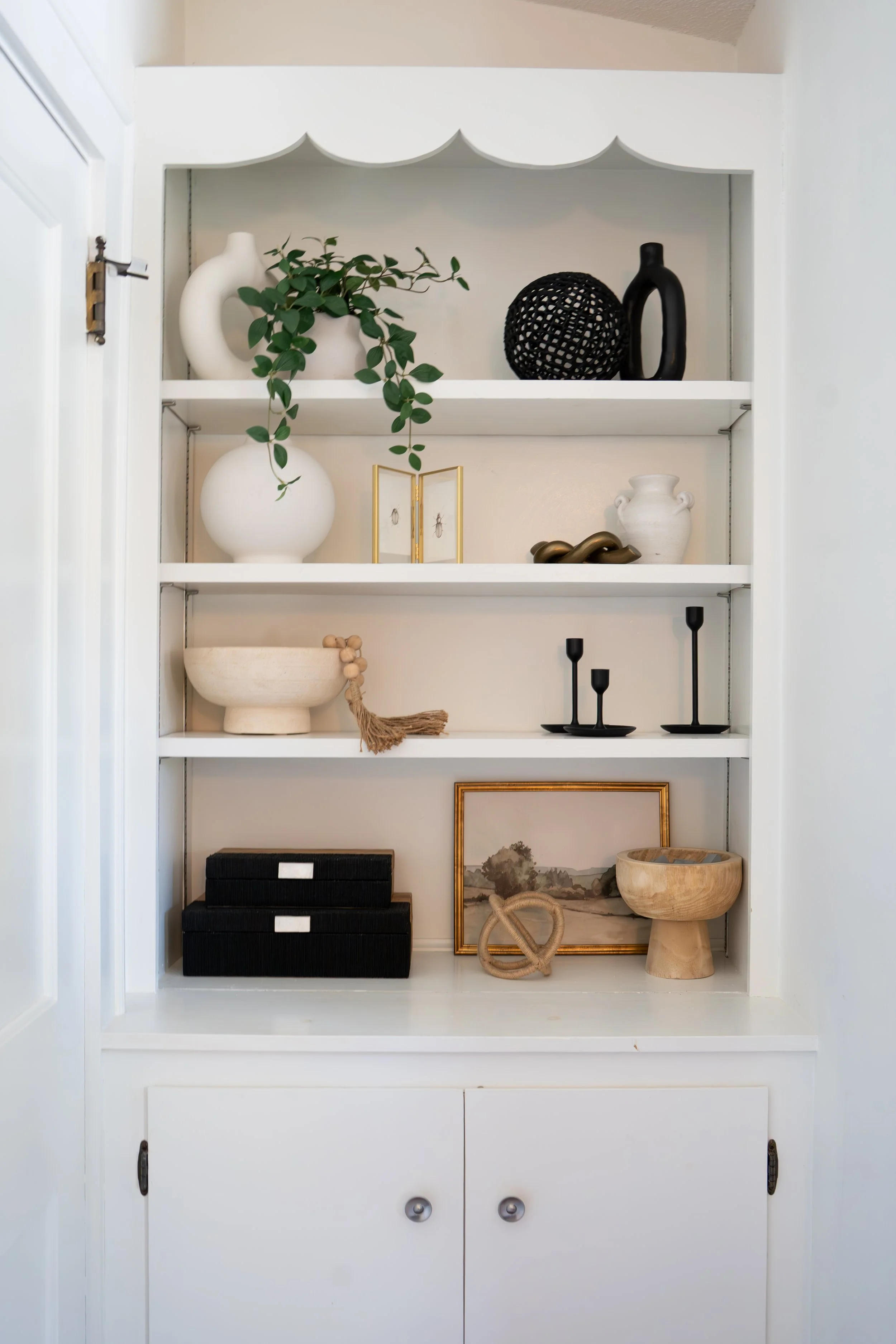 Curated built-in bookshelf with styled books, plants, and decorative objects — LR Studio interior styling