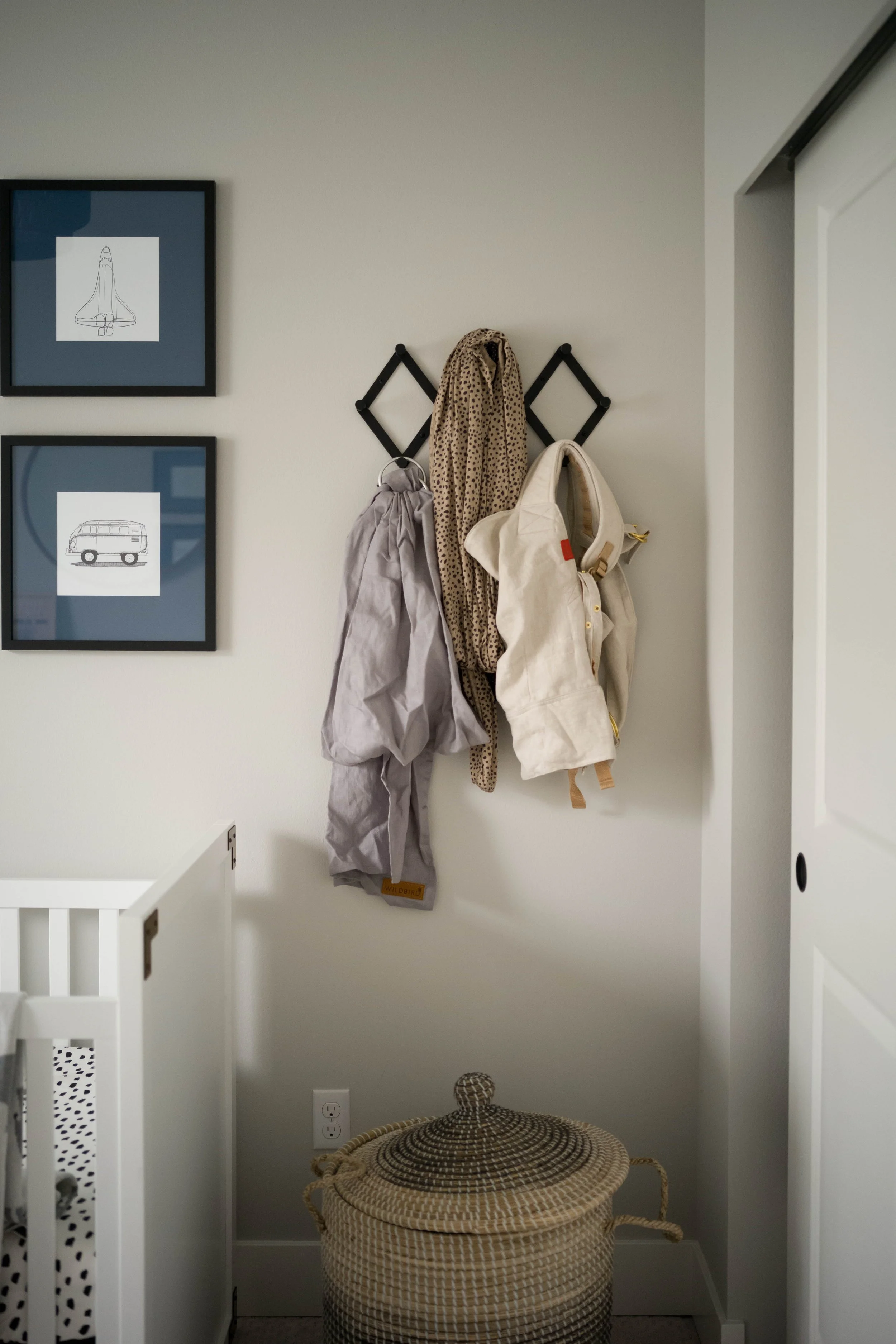 Styled mudroom entryway with wall hooks, framed art, and woven basket — LR Studio home styling